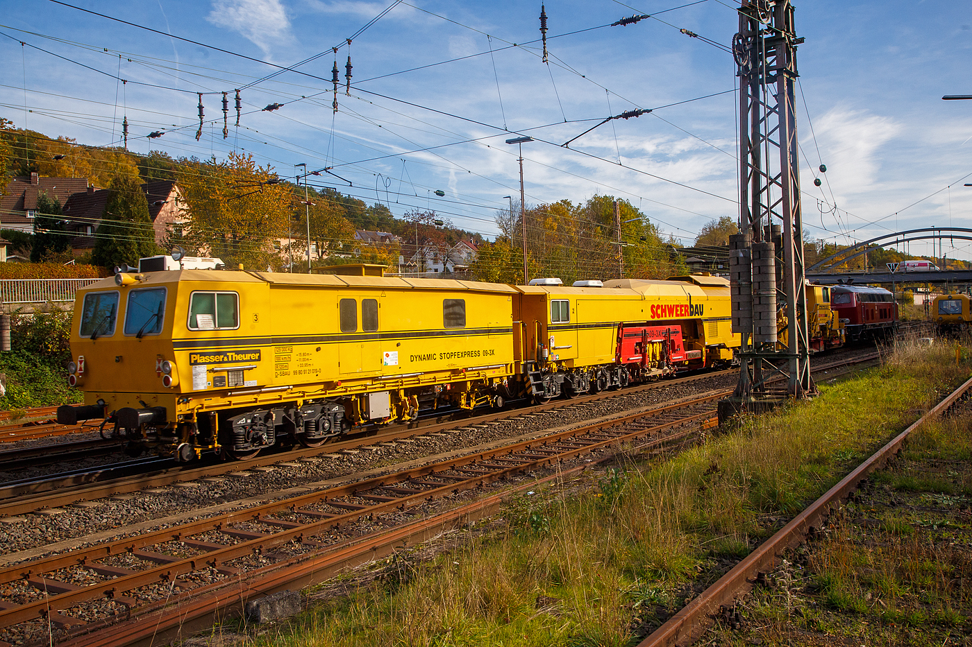 Als Schlussläufer am Haken der 218 155-0 am 30.10.2022 bei der Durchfahrt in Kreuztal in Richtung Süden, der Plasser & Theurer Dynamic Stopfexpress 09-3X, Schweres Nebenfahrzeug Nr. D-SBAU 99 80 9121 019-0 der Schweerbau, davor der P&T Schotterpflug SSP 110 SW, Schweres Nebenfahrzeug Nr. D-SBAU 99 80 94 25 049-0.