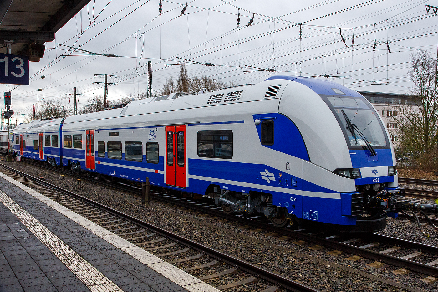 Auf �berf�hrungsfahrt (wohl zu einem Nordseehafen)...
Die zwei SIEMENS Desiro HC Triebendwagen 6292 (94 95 0006 292-0 IL-IR) und 6291 (94 95 0006 291-x IL-IR), ohne die vier zugeh�rigen Doppelstock-Zwischenwagen, f�r/der Israel Railways/ (רַכֶּבֶת יִשְׂרָאֵל / Rakkevet Israel - RI), werden am 14 Februar 2024 von der RP 218 402-6 „Pidder L�ng“ durch den Bahnhof Hamm (Westfalen) geschleppt.

2018 wurde bekannt, dass RI 6 vier- und 18 sechsteilige elektrische Triebz�ge vom Typ Desiro High Capacity bei Siemens Mobility bestellt hatte. Au�erdem besteht eine Option auf 36 weitere Triebz�ge. Zu den Fahrzeugen kommt auch noch die Errichtung einer Wartungsanlage in Aschqelon sowie die Wartung der Fahrzeuge durch Siemens Mobility hinzu. Die Z�ge sollen im Raum Tel Aviv / Jerusalem zum Einsatz kommen. Dies ist die erste Bestellung von Desiro HC f�r einen Einsatz au�erhalb Deutschlands. Im Jahr 2021 wurden die ersten Z�ge im Pr�fcenter Wegberg-Wildenrath getestet und im November 2021 �ber Aschdod per Schiff angeliefert. Bei Bestellung aller Z�ge wird der Vertragswert auf 975,3 Millionen US-Dollar (910 Millionen US-Dollar f�r die Z�ge und 65,3 Millionen US-Dollar f�r die 15-j�hrige Instandhaltung von 24 Triebz�gen) beziffert.

Die vierteiligen Triebz�ge haben die UIC-Nummer 94 95 0004 0xx-y IL-IR, die sechsteilige elektrische Triebz�ge die UIC-Nummer 94 95 0006 xxx-y IL-IR.

TECHNISCHE DATEN der Desiro HC:
Spurweite: 1.435 mm (Normalspur)
Achsformel: Bo’Bo’+2’2’+2’2’+Bo’Bo’ (vierteilig)
Achsformel: Bo’Bo’+2’2’+2’2’+2’2’+2’2’+Bo’Bo’ (sechsteilig)
Zugl�nge �ber Kupplung: 105.252 mm (vierteilig) / 157.252 mm (sechsteilig)
Wagenl�nge Endwagen: 26.226 mm
Wagenl�nge Mittelwagen: 25.200 mm
Leergewicht: 260 t / 388 t
H�chstgeschwindigkeit: 160 km/h
Kurzzeitleistung: 4.800 kW
Beschleunigung: 1,1 m/s�
Stromsystem: 25 kV, 50 Hz ~
Strom�bertragung: Oberleitung
Sitzpl�tze: 	405 (vierteilig) / 655 (sechsteilig)
Fu�bodenh�he (Einstieg): 800 mm (Endwagen) 730 mm (Mittelwagen)

