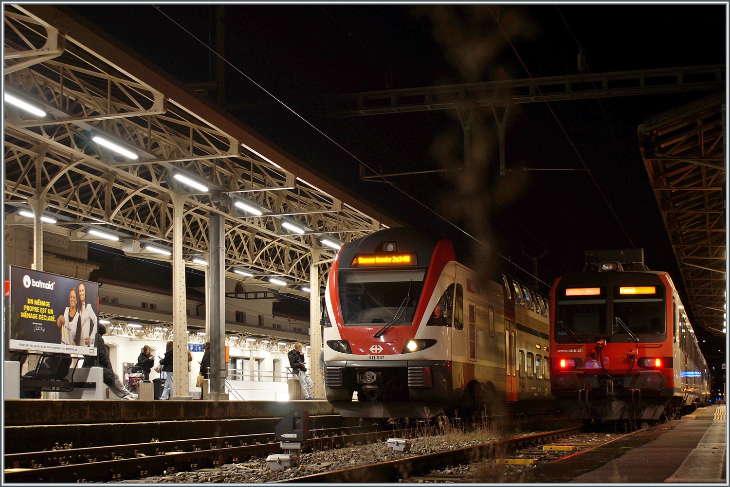 Beim Umsteigen in Vevey nach der Arbeit versuchte ich noch die  Bonne Année 2024  Anschrift festzuhalten, dies jedoch mit eher mässigem Erfolg. Bei der Aufnahme nicht gesehen hatte ich den kleine Strauch direkt vor der Kamera, der erst beim Bearbeiten auftauchte!
Trotzdem finde ich die Stimmung zeigenswert. Im Bahnhof von Vevey stehen der SBB RABe 511 037 nach Annemasse und ein SBB Domino, der auf der  Train de Vignes  Linie im Einsatz ist. 

1. Jan. 2024