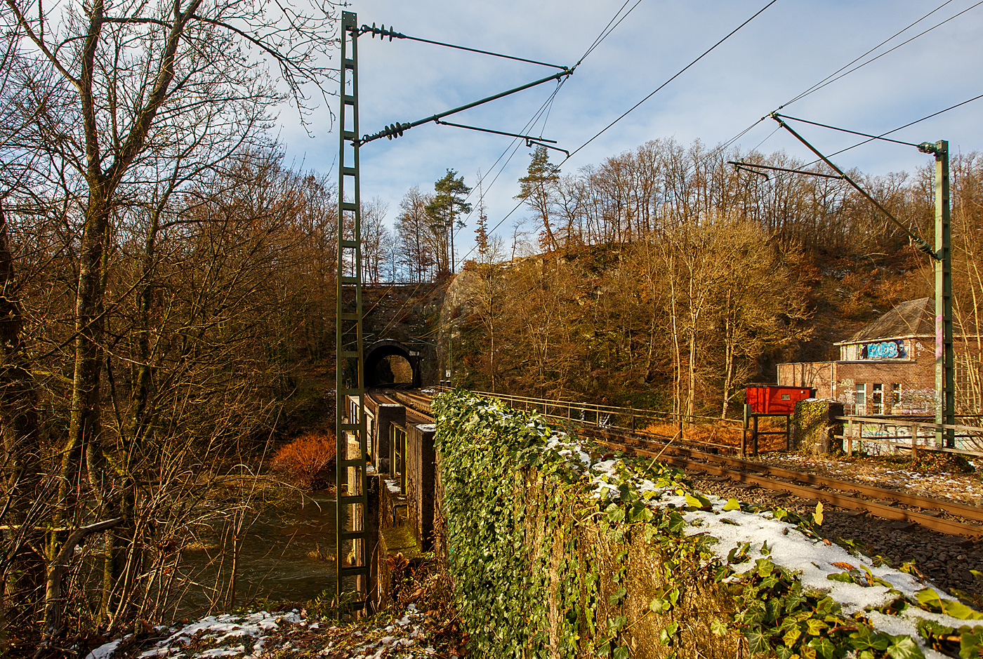 Beim Wiederlager der Siegbrücke beim Bahnhof Scheuerfeld (Sieg) mit dem Blick über die Brücke zum 32 m langen Mühlburg-Tunnel der Siegstrecke (KBS 460) bei km 79,4 am 02.12.2023.