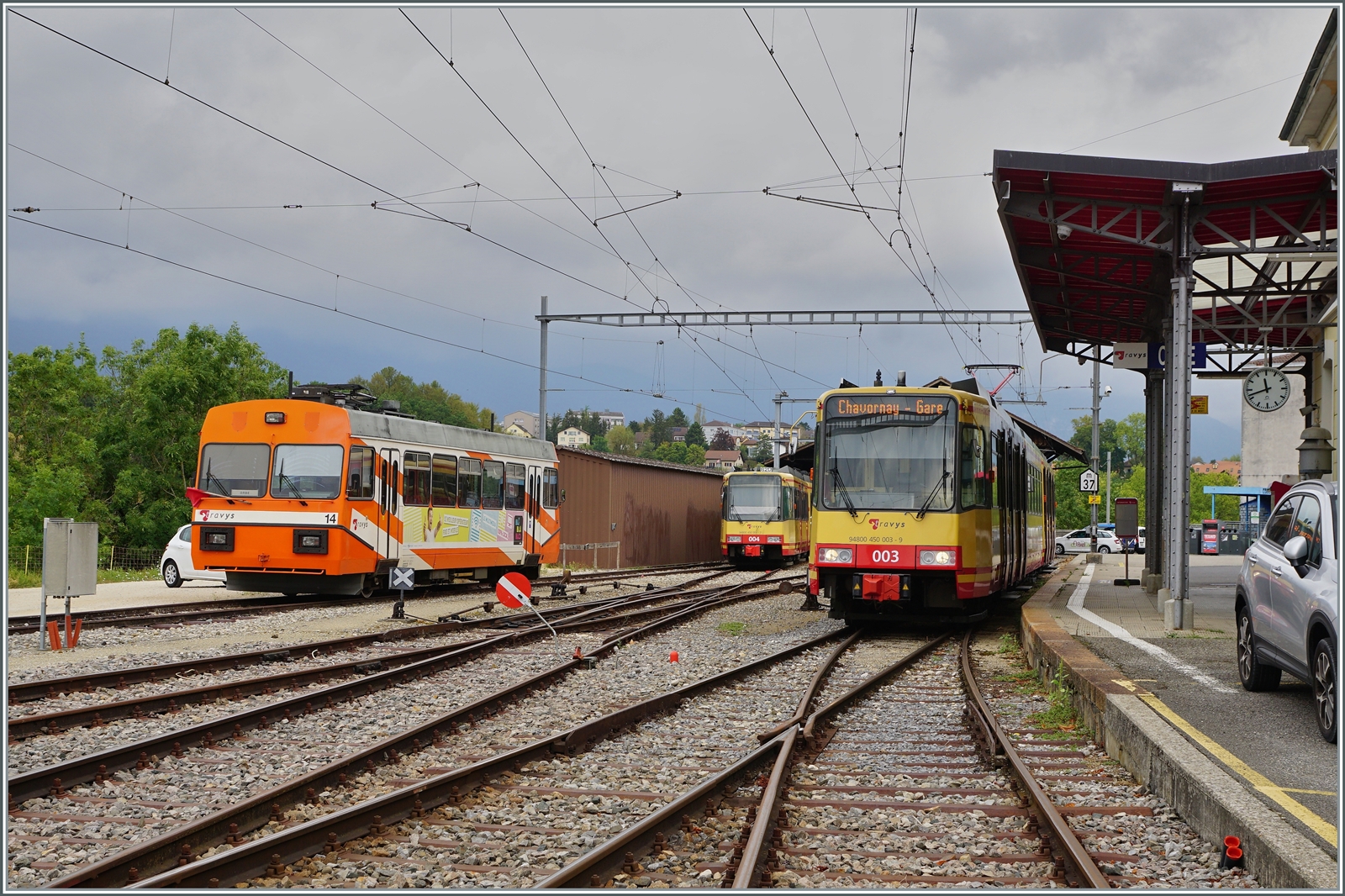 Bis zur Realisierung der Stromsystemumstellung und besonders der Umbauarbeiten in Chavonray sind bei der TRAVYS / OC zwei Be 4/8 (GT8-100D/2S) im Einsatz. Das Bild zeigt den aus Chavornay in Orbe ankommenden Be 4/8 003 (94 80 0450 003-9). Im Hintergrund der auf einen neuen Stromabnehmer wartende Be 4/8 004 und ganz links im Bild der defekte Stadeler Be 2/2 14.

15. August 2022