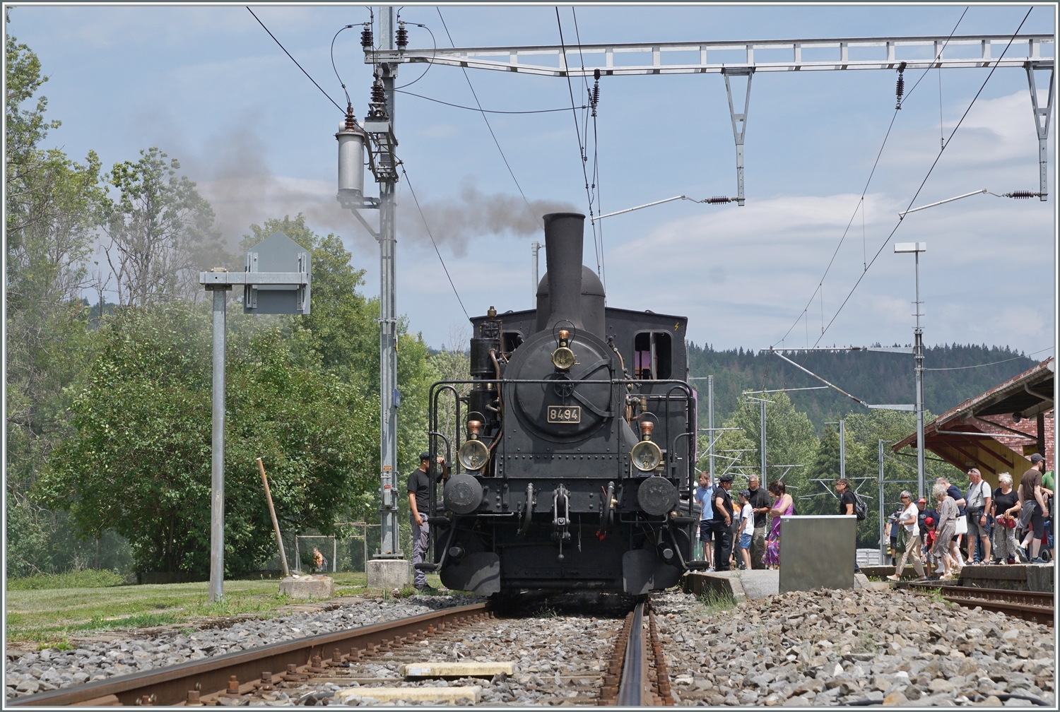  Bitte Einsteigen!  Das CTVJ (Compagnie du Train à Vapeur de la Vallée de Joux) Tigerli E 3/3 8494 (UIC 90 85 0008 494-6) der SLM mit Baujahr 1909 wartet in Le Pont mit seinem Sonderzug auf die Gäste für die Fahrt nach Le Brassus. Das Bild entstand auf dem geöffneten Bahnübergang.

23. Juli 2023