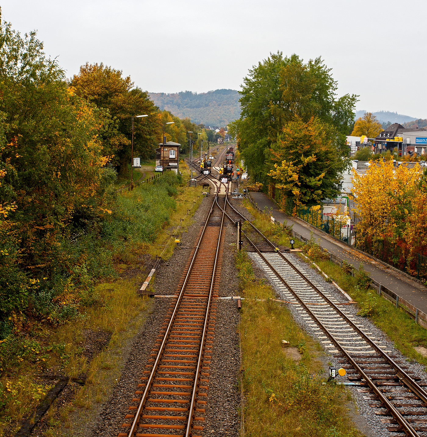 Blick auf den Bahnhof Herdorf und die Baustelle in Blickrichtung Betzdorf am Mittag des 12 Oktober 2025. Die Weichen 25 und 26 sind beide eingebaut, müssen noch eingeschottert werden, zurzeit haben die Gleisbauarbeiter aber ihre wohlverdiente Mittagspause. 

Übrigens hier kann man deutlich die Grenze der Streckenkassen der Bahnstrecke Betzdorf–Herdorf-Haiger „Hellertalbahn“ (KBS 462). Bis kurz hinter der Weiche 27, zum Gleisanschluss des Rangierbahnhofs der KSW (Betriebsstätte Freien Grunder Eisenbahn KSW NE447 / DB-Nr. 9275), ist die Streckenkasse D4 (Achslast 22,5 t / Meterlast 8,0 t/m). Links ab der ersten Stahlschwelle hinter der Weiche hat die Strecke in Richtung Haiger dann die Streckenkasse CE (Achslast 20,0 t / Meterlast 8,0 t/m). Rechs das Gleis ab der Gleissperre ist das Anschlussgleis der KSW (Kreisbahn Siegen-Wittgenstein) und gehört auch der KSW. 

Was ich nicht verstehe das man in Deutschland Bahnstecken wieder, für sehr hohe Kosten, reaktiviert. Was ich auch gut finde, aber hier würde ich mir einen Ausbau auf komplett D4 wünschen. Auch eine Elektrifizierung der Strecke oder gar eine Reaktivierung des zweiten Gleises der 36 Kilometer langen Strecke, könnte ich mir vorstellen, die Strecke war früher ja zweigleisig. Dann müsste der Güterverkehr nicht den Umweg über Siegen machen. 
