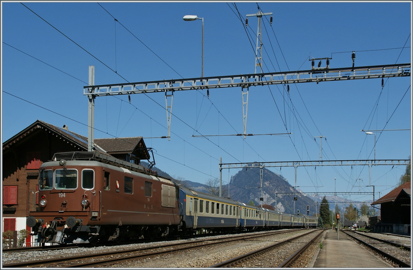 BLS Re 4/4 190 - 195 ab 1982; die BLS Re 4/4 194  Thun  schiebt in Leissigen einen BLS RE in Richtung Interlaken Ost, welcher aus BLS Wagen mit der freundlichen Farbgebung der 80er Jahren gehalten sind. 

9. April 2011 
