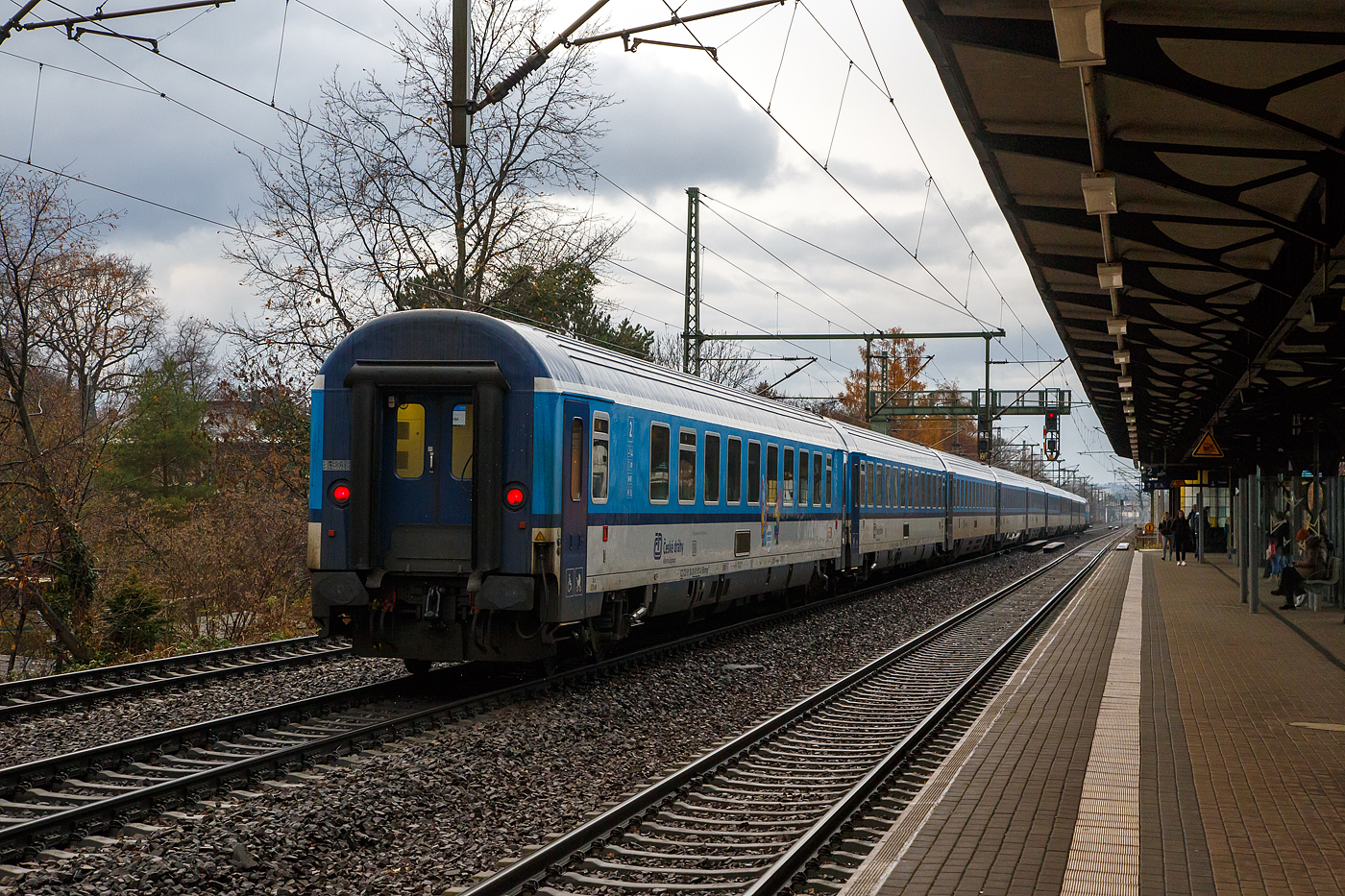 Da f�hrt er dahin der ČD - Česk� dr�hy EC 378  „Berliner“ (Praha hl.n – Dresden Hbf - Berlin Hbf (tief) - Hamburg Hbf - Kiel Hbf), am 07.12.2022 gezogen von der 193 298-7 “Mike� 60” durch 

Am Zugschluss als Wagen 255 hier der EuroCity 2. Klasse klimatisierter Gro�raumwagen (Reisezugwagen) mit Gep�ckabteil, CZ-ČD 61 54 20-91 013-0 der Gattung Bhmpz 228, der ČD - Česk� dr�hy (Tschechischen Eisenbahnen).

Der 48t schwere Wagen hat 55 Sitzpl�tze in der 2. Klasse, 4 Klappsitze sowie 2 Rollstuhlpl�tze. Die Pl�tze Nr. 25 und 27 sind f�r Behinderte, Nr. 14-17 und 31-38 f�r Reisende mit Kindern (Kinderabteile). Auch eine rollstuhlgerechte Toilette ist vorhanden.