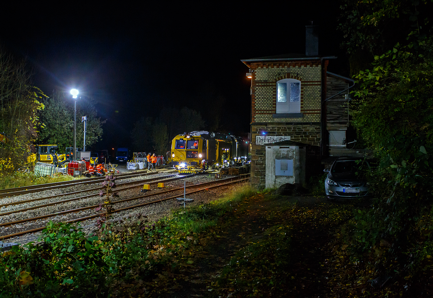 Damit hatte ich nicht gerechnet, aber als ich erkannte was es ist, so musste ich trotz der Dunkelheit nochmal zur Baustelle. Ich hatte eher an eine Maschine der DGU gedacht, da die KAF Falkenhahn Bau AG dort Miteigentümer ist, aber nein es war eine hochmoderne Maschine der Eiffage Infra-Rail. 

Die Baustelle Bahnhof Herdorf am Abend des 26 Oktober 2025 (20:32 Uhr), nun wird gleich die neue Weiche 3, beim Bahnhof/Stellwerk Herdorf Fahrdienstleiter (Hf), gestopft. Hier kam die recht neue Plasser & Theurer UNIMAT 09-4x4/4S E³ (A-PLA 99 81 9124 004-8), eine Universal-Weichenstopfmaschine mit Hybrid-Antriebstechnik, der Firma Eiffage Infra-Rail GmbH (Herne) zum Einsatz. Ob die Maschine nur von Eiffage Infra-Rail gemietet oder nun gekaut wurde ist mir nicht klar, aber eingestellt ist sie in Österreich über Franz Plasser Vermietung von Bahnbaumaschinen GmbH. 