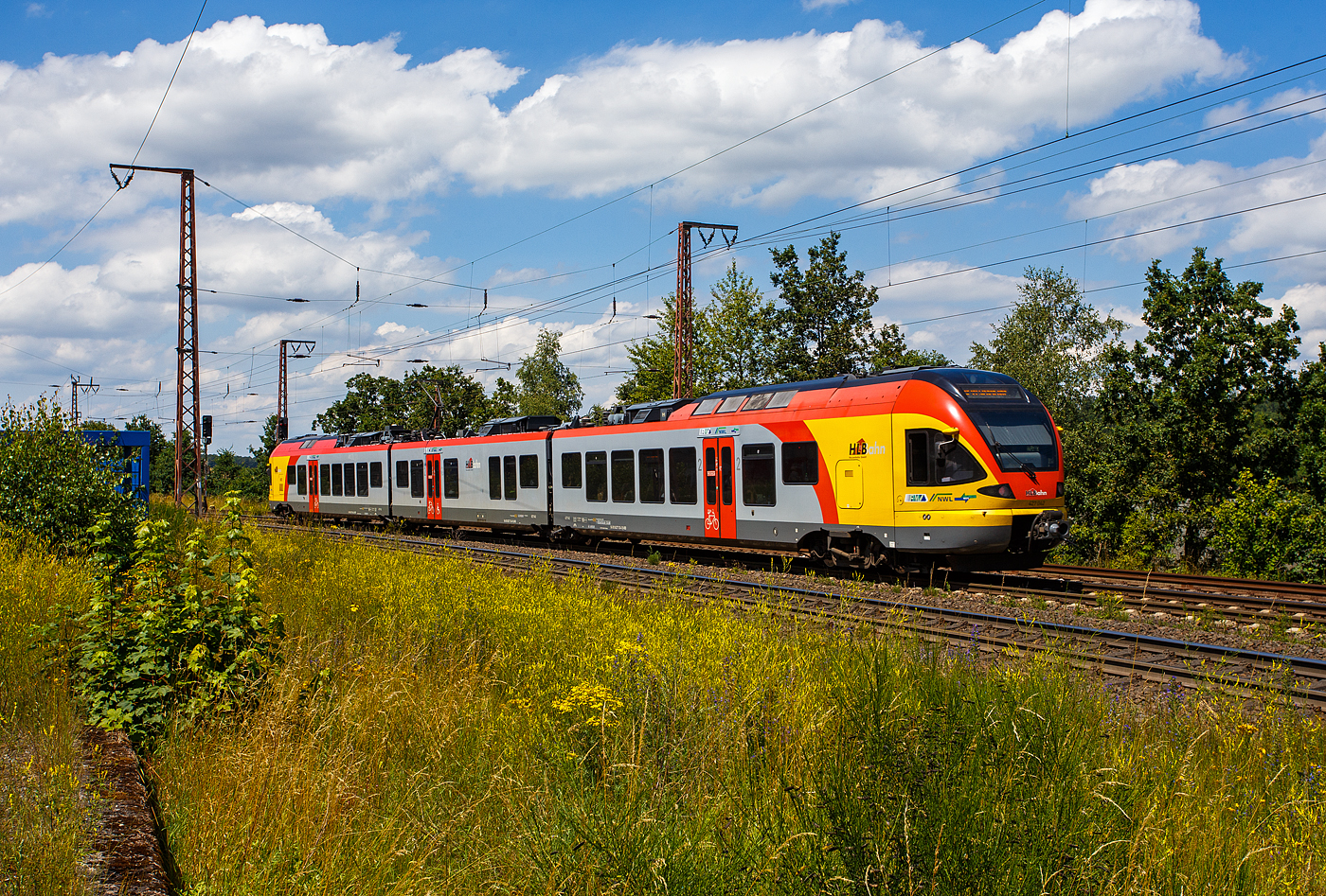 Der 3-teilige Stadler FLIRT 427 542 / 827 042 / 427 042 (94 80 0427 624-2 D-HEB / 94 80 0827 124-9 D-HEB / 94 80 0427 124-3 D-HEB) der HLB (Hessischen Landesbahn) fährt am 11 Juli 2024, als RE 99 „Main-Sieg-Express“ (HLB24512) Frankfurt am Main – Geißen – Siegen Hbf, durch Rudersdorf (Kreis Siegen) in Richtung Siegen.

Der Triebzug wurde 2010 von Stadler Pankow in Berlin unter den Fabriknummern 38623 bis 38625 gebaut und an die HLB geliefert
