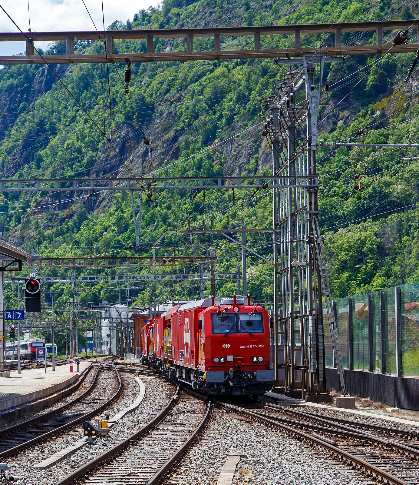 Der 4-teilige L�sch- und Rettungszug „Brig“ (ein vierteiliger LRZ 18) der SBB Infrastruktur erreicht am 25 Mai 2023 seinen Heimatbahnhof Brig.

Der L�sch- und Rettungszug wurde 2018 f�r die SBB Infrastruktur, Depot Brig, gebaut und besteht aus dem:
Rettungsfahrzeug 1 - Xtmas 99 85 9174 023-3 CH-SBBI;
Rettungsfahrzeug 2 - Xtmas 99 85 9174 013-4 CH-SBBI;
Tankl�schwagen - Xans 99 85 9375 013-1 CH-SBBI; sowie
Ger�tefahrzeug - Xtmas 99 85 9177 013-1 CH-SBBI

Die neuste Generation der L�sch- und Rettungsz�ge (LRZ 2018) ist vierteilig und besteht aus einem Tankl�schwagen, einem Ger�tefahrzeug und zwei Rettungsfahrzeugen. Der Antrieb erfolgt mit je zwei MTU-Dieselpowerpacks (6-Zylinder Turbo geladener Dieselmotor von MTU, Partikelfilter, Turbogetriebe mit eingebauten Retarder und K�hlsystem) nach EU-Abgas-Emissionsstufe IIIA Norm, mit je 390 kW Leistung �ber die beiden Rettungs- sowie das Ger�tefahrzeug. Der L�sch- und Rettungszug hat so eine installierte Gesamtleistung von 2.340 kW (6 x 390 kW), eine H�chstgeschwindigkeit von 100 km/h und kann Anh�ngelasten von 940 Tonnen bei einer Steigung von 27 Promille bewegen, in der Ebene sogar mit einem Gewicht von �ber 1.600 t. 

Der Tankl�schwagen ist nicht selbstfahrend, er ist als Steuerwagen ausgef�hrt, daher auch die Gattungsbezeichnung Xans. Er besitzt zwar einen Deutz 6-Zylinder- Dieselmotor (mit 238 KW Leistung) mit vollautomatischem Partikelfilter, einer und angeflanschtem Pumpenaggregat von Vogt, dieser wird aber nur Wasser- und Schaummittelpumpen ben�tigt.

Der gesamte Atemluftvorrat des Zuges betr�gt 1.980.000 Normliter und wird in 132 Speicherflaschen, die ein Volumen von 50 Litern haben, mit 300 Bar Druck gelagert. An verschiedenen Orten in den Innenr�umen und auf den Plattformen sind Anschl�sse f�r die Atemluftversorgung vorhanden. Daran k�nnen separate Atemschutzmasken oder das tragbare Atemschutzger�t mit Geber- und Nehmerschlauch angeschlossen werden. Alle F�hrerstandkabinen sind druckdicht und verf�gen �ber eine Atemluftversorgung, welche einen �berdruck erzeugt. In den F�hrerstandkabinen des Ger�tefahrzeugs und des Tankl�schwagens ist zus�tzlich ein Bedienpult f�r die Feuerl�schtechnik eingebaut.

Zwischen 4 und 5 Stunden  ist ein autonomer Betrieb des LRZ m�glich.

Im Einsatz wird der Zug in zwei Einheiten geteilt. Die erste Einheit aus Ger�tefahrzeug und Tankl�schwagen (mit 780 kW Antriebsleistung) dient der Feuerbek�mpfung und dem Bergungsarbeiten. Die zweite Einheit (mit 1.560 kW Antriebsleistung), bestehend aus zwei Rettungsfahrzeugen �bernimmt im Shuttleverkehr den Personentransport zu einem sicheren Ort.

Quellen: SBB und Anschriften
Stand (�berarbeitung): September 2025
