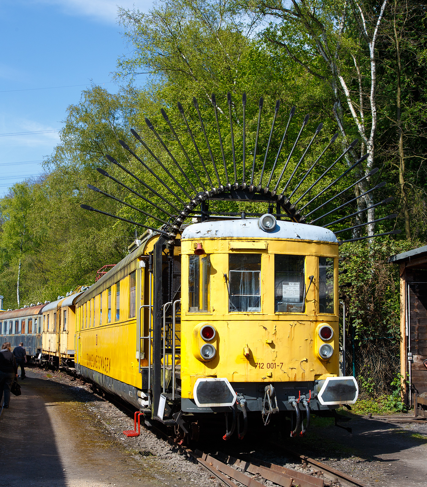 Der „Tunneligel“  712 001-7, ex DB Karlsruhe 6210, am 30.04.2017 im Eisenbahnmuseum Bochum-Dahlhausen.

Unter der Bezeichnung 712 001-7 setzte die Deutsche Bundesbahn von 1965 bis 1993 diesen Tunnelmesswagen ein, welcher wegen seines charakteristischen Erscheinungsbildes auch „Tunneligel“ genannt wird. Er verfügte neben mechanischen Messeinrichtungen zur Vermessung des Tunnel-Profils, auch über einen Messstromabnehmer, mit dem die Höhe der Oberleitung gemessen werden konnte. 

Recht selten wurden früher Bahndienstfahrzeuge als Neufahrzeuge ab Hersteller in Dienst gestellt. Meist wurden für derartige Zwecke Fahrzeuge verwendet, die im normalen Betrieb nicht mehr benötigt wurden. So entstand der hier gezeigte Tunnelmesswagen 712 001 im Jahr 1965 aus dem Eilzugtriebwagen VT 137 158 (ab 1957 – VT 38 002), welcher im Oktober 1960 ausgemustert worden war. Nach dem Umbau zum Messtriebwagen wurde er im September 1965, in roter Farbgebung, mit der Bezeichnung Karlsruhe 6210, wieder in Dienst gestellt. Seit 01.01.1968 trägt er dann, als Bahndienstfahrzeug, die EDV-gerechte Fahrzeugnummer 712 001-7. In den 1980er Jahren wurde er in das einheitliche gelb der Bahndienstfahrzeuge umlackiert.

Beim Umbau wurde ein Fahrzeugende völlig verändert. Der Fahrzeugstand 2 wurde vom Aufbau abgetrennt und auf das um 1.170 mm verlängerte Untergestell wieder aufgesetzt. In den entstandenen Zwischenraum wurden dann die Messfühler und die weiteren Messeinrichtungen  eingebaut. Das Fahrzeuginnere wurde völlig neu gestaltet. Die alten Fahrgasträume verschwanden, es wurden eine Werkstatt, Küche, Übernachtungsräume und der Messraum eingebaut. So konnte die Mannschaft während längere Messeinsätze, die in ganz Deutschland stattfanden, im Tunnelmesswagen an Bord bleiben. Die Tür und Fenstereinteilung blieb beim Umbau unverändert.

Tunnelprofile müssen in regelmäßigen Abständen überprüft werden. So wird überwacht, ob das Lichtraumprofil z.B. durch Bergsenkungen beeinträchtigt ist und dadurch Gefahren im Zugverkehr entstehen können. Dazu befährt der Tunnelmeßtriebwagen den zu messenden Tunnel mit ausgeklappten Messfühlern (wie hier zu sehen). Stoßen diese an die Tunnelwandung, so geben diese nach und neigen sich. Diese Änderung der Lage wird über Seilzüge in den Messraum übertragen und aufgezeichnet. Im Vergleich zu früheren Messungen kann nun festgestellt werden, ob sich das Tunnelprofil im Laufe der Zeit verändert hat. Dieser 712 001 wurde im Jahr 1994 durch den Profil-Messtriebwagen 712 002 (PROM), Baujahr 1993 von der Deutschen Plasser,  abgelöst.
Der Messwagen ist jedoch noch voll funktionstüchtig.

Das Maschinendrehgestell trägt auf einer Rahmenkonstruktion den Dieselmotor und den BBC-Generator für die elektrische Kraftübertragung. Zwei Gleichstrom-Fahrmotoren trieben die zwei Treibachsen an. Eine Langsamfahrschaltung ermöglicht konstante Geschwindigkeiten zwischen 2 und 6 km/h.

TECHNISCHE DATEN:
Gebaute Anzahl: 1
Baujahr: 1935 als VT 137 / 1965 Umbau zum Tunnelmesswagen
Hersteller (mechan. Teil) : MAN, Nürnberg
Hersteller (elektrischer Teil) : BBC, Mannheim
Spurweite: 1.435 mm (Normalspur)
Achsfolge: 2' Bo' 
Länge über Puffer:  21.880 mm
Dienstgewicht:  49,1 t
Höchstgeschwindigkeit:  100 km/h 
Antrieb: Diesel-elektrischer Antrieb 
Motor: Zwölfzylinder-Viertakt-Dieselmotor mit angebautem BBC-Generator
Installierte Leistung:  441 kW (600 PS)
Fahrmotoren: 2 Stück Gleichstrommotor mit je 180 kW Leistung
Treibraddurchmesser: 1.000 mm
Laufraddurchmesser: 900 mm


Noch ein paar Worte zu den DB VT 38 000–003, ex DR VT 137 156–159, da nur dieser in abgeänderter Form erhalten geblieben ist:
Die Triebwagen-Baureihe DR 137 156 bis 159 waren dieselelektrische Triebwagen nach dem Muster der DR 137 094 bis 223, die mit einem aufgeladenen Zweiwellen- Dieselmotor von MAN ausgerüstet waren. Durch die erhöhte Motorleistung konnten sie auf steigungsreichen Strecken eingesetzt werden. Die Fahrzeuge gelangten nach 1945 in den Bestand der Deutschen Bundesbahn und wurden als Baureihe VT 38.0 bezeichnet. Ihr Einsatz dauerte bis 1965..

Geschichte
Da die Maybach-Motorenbau GmbH ihre Motorenpalette durch Motoraufladung in der Leistung steigern konnte, entschloss sich auch MAN für seine Zweiwellenmotoren zu dieser Maßnahme. Die Deutsche Reichsbahn bestellte vier Fahrzeuge mit dieser Motorkonfiguration, um Vergleiche bezüglich der Leistungsfähigkeit und der Fahrdynamik zu erhalten. Besonderes Augenmerk wurde dabei auf den Steuerwagenbetrieb und beim Einsatz in schwierigen topografischen Verhältnissen gelegt. Die Fahrzeuge entsprachen dem Einheitsgrundriss und wiesen bedingt durch die geänderte Antriebsanlage einige Änderungen in der Maschinenanlage auf. Äußerlich waren sie als geänderte Einheitstriebwagen zu erkennen.

Die Fahrzeuge wurden überwiegend auf der Schwarzwaldbahn eingesetzt. Dabei haben die Triebwagen in den drei Jahren bis Kriegsbeginn Laufleistungen zwischen 140.000 und 200.000 Kilometer zurückgelegt. Alle Fahrzeuge überstanden den Zweiten Weltkrieg und verblieben nach Kriegsende in den Westzonen. Sie erhielten 1947 die neue Bezeichnung VT 38 000–003.

Nach Kriegsende waren die Triebwagen lange abgestellt und wurde 1949 nach gründlicher Aufarbeitung im Ausbesserungswerk Friedrichshafen wieder in Betrieb genommen. 1954 wurde für die drei noch verfügbaren Triebwagen der Motortausch mit dem Maybach GTO 6 verfügt. Vollzogen wurde er lediglich bei VT 38 002 und VT 38 003. Bei den Triebwagen mit getauschtem Motor blieb die Baureihenbezeichnung unverändert. Die VT 38 000 und VT 38 001 erhielten keinen neuen Motor, ersterer schied bereits 1952 aus, der VT 38 001 1955. Die verbliebenen Wagen taten Dienst bis 1960 und 1962. Während VT 38 003 nach der Ausmusterung zerlegt wurde, wurde VT 38 002 als Tunnelmesswagen 6210 Kar und ab 1968 712 001-7 weitergenutzt. In dieser Form diente er bis 1993 und wurde danach in den Bestand des Eisenbahnmuseums Bochum-Dahlhausen übernommen.