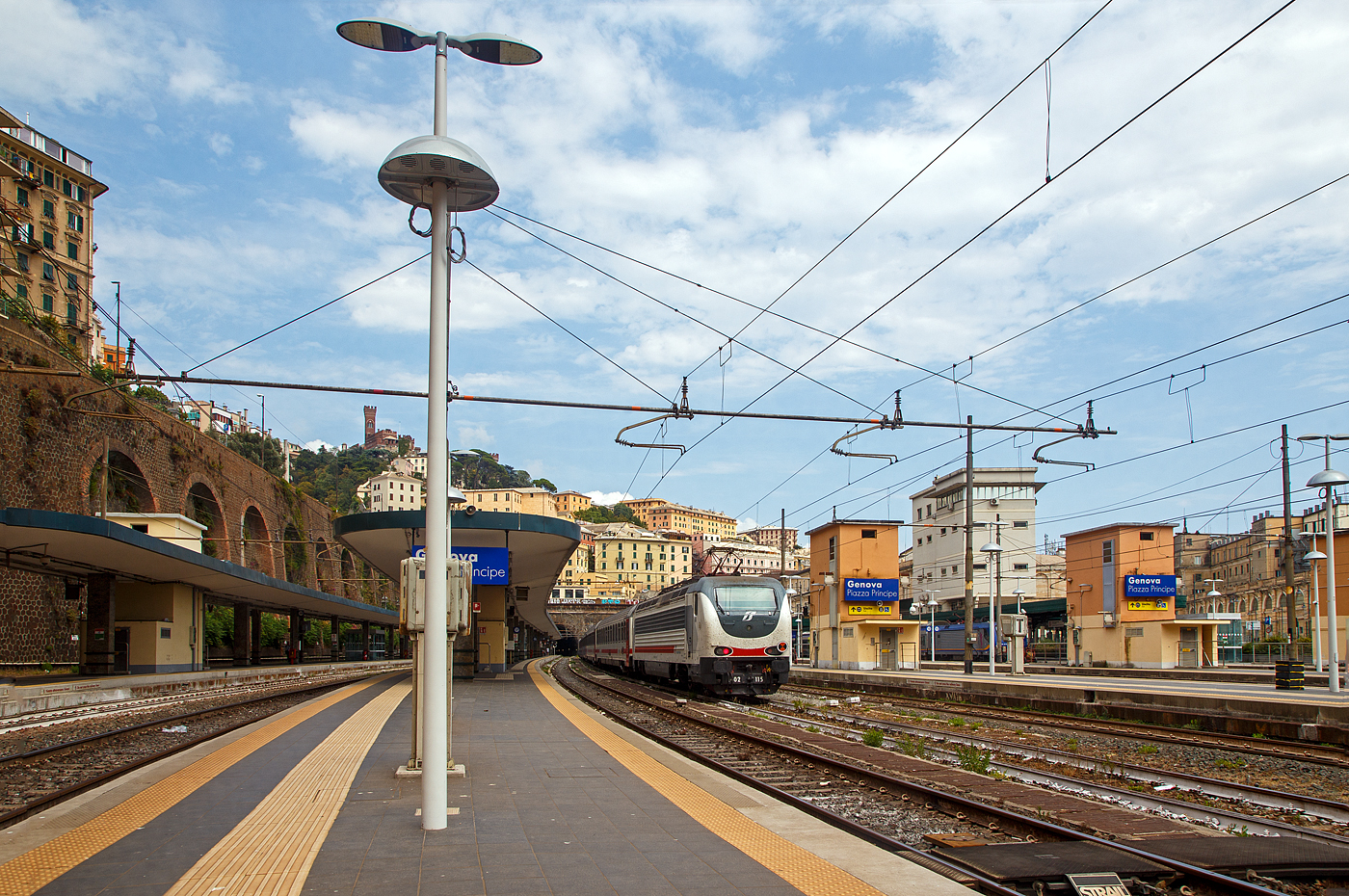 Der Bahnhof Genua / Genova Piazza Principe (Blickrichtung Osten) am 23 Juli 2022. Mittig ein angestellter Trenitalia Intercity im Sandwich zweier E.402 B (hier am Zugschluss die E 402.115). 

Oben die Burg D'Albertis (italienisch Castello d'Albertis) sie ist eine historische Residenz.

Der Bahnhof Genova Piazza Principe ist einer der zwei Hauptbahnhöfe der italienischen Hafenstadt Genua. Er liegt im nordwestlichen Bereich des Stadtzentrums, zwischen der Piazza Acquaverde, wo sich die Passagierzugänge befinden, und der Piazza del Principe. Das Bahnhofsgebäude nimmt den gesamten nördlichen Abschnitt der Via Andrea Doria ein, hier befinden sich die Servicezugänge. In kurzer Entfernung liegt der imposante Palazzo del Principe. Der zweite Hauptbahnhof der ligurischen Hauptstadt ist der Bahnhof Genova Brignole.