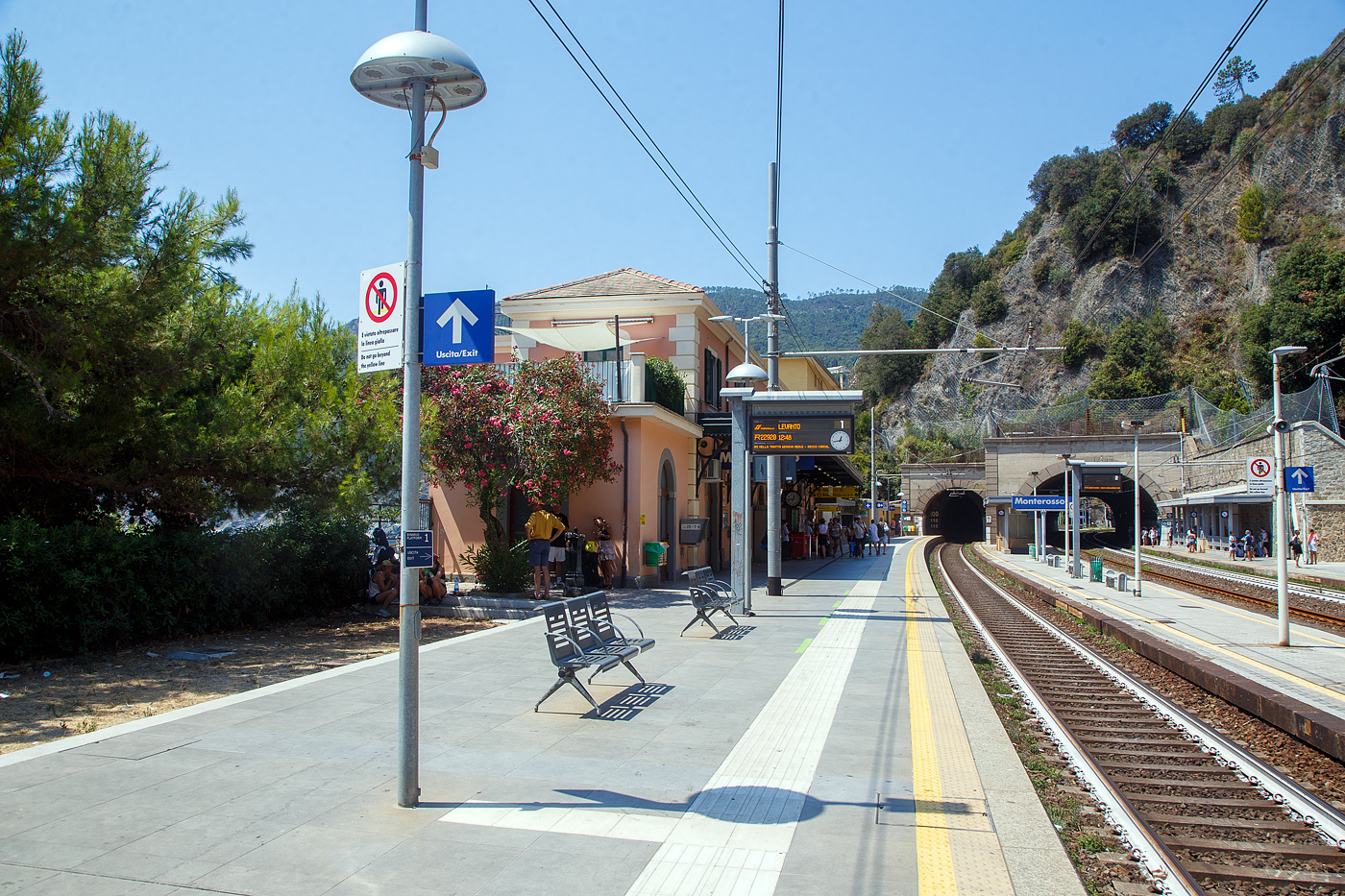 Der Bahnhof Monterosso Cinque Terre (komplette Bezeichnung der Gemeide Monterosso al Mare) an der Italienischen Riviera. Von den Cinque Terre Bahnhöfen hat Monterosso die längsten Bahnsteige unter freiem Himmel, so halten hier auch Intercity-Züge. 

Das Fischerdorf Monterosso al Mare ist das nördlichste Dorf und mit rund 1700 Einwohnern der größte Ort der Cinque Terre an der Italienischen Riviera. Monterosso erstreckt sich über rund 1,5 Kilometer und ist zweigeteilt, die kleine Altstadt ist vom neueren Viertel Fegina durch einen ins Meer ragenden Felsen getrennt, auf dem sich der markante Wachtturm Torre Aurora aus dem 16. Jahrhundert erhebt. Durch den Felsen führt ein rund 100 m langer Fußgängertunnel.