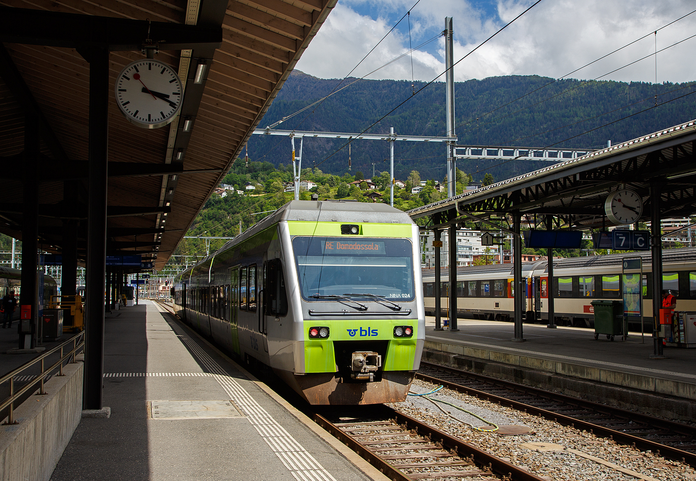 Der BLS NINA der 3. Serie RABe 525 024 (94 85 7525 024-6 CH-BLS) steht am 25.Mai 2023 im Bahnhof Brig, als RE nach Domodossola (Italien), zur Abfahrt bereit. 

Eigentlich sollten die BLS RABe 528 “MIKA” von Bern über die Lötschberg-Bergstrecke (Kandersteg) und Brig nach Domodossola fahren, aber diese haben noch keine Zulassung für Italien, die sie hinter dem SBB) Simplontunnel bis Domodossola brauchen. Und so wird der Zuglauf in Brig gebrochen und “NINA” fahren (min. bis zum Sommer) als Ersatz.