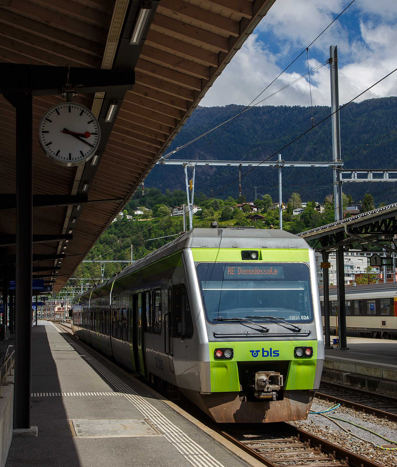Der BLS NINA der 3. Serie RABe 525 024 (94 85 7525 024-6 CH-BLS) steht am 25.Mai 2023 im Bahnhof Brig, als RE nach Domodossola (Italien), zur Abfahrt bereit. 

Eigentlich sollten die BLS RABe 528 “MIKA” von Bern über die Lötschberg-Bergstrecke (Kandersteg) und Brig nach Domodossola fahren, aber diese haben noch keine Zulassung für Italien, die sie hinter dem SBB) Simplontunnel bis Domodossola brauchen. Und so wird der Zuglauf in Brig gebrochen und “NINA” fahren (min. bis zum Sommer) als Ersatz.