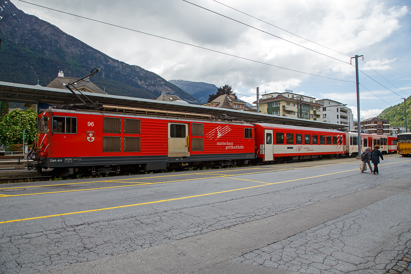 Der Deh 4/4 II - 96  Münster   der Matterhorn-Gotthard-Bahn (MGB), ex FO 96  Münster   (Furka-Oberalp-Bahn), am 25.05.2023 mit einen Regionalzug von Andermatt nach Visp im Bahnhof (Vorplatz) Brig.

Der Gepäcktriebwagen wurde 1984 von SLM (mechanischer Teil, Lokomotivkasten) und BBC (elektrische Ausrüstung) gebaut.

Der Deh 4/4 II ist ein schmalspuriger Gepäcktriebwagen der Matterhorn-Gotthard-Bahn (MGB) für Adhäsions- und Zahnradbetrieb. Weil die Furka-Oberalp-Bahn (FO) mit den Deh 4/4 I gute Erfahrungen gemacht hatte, beschaffte sie die Deh 4/4 II als Nachfolger. Im Zuge des Zusammenschlusses der FO mit der BVZ kamen sie zur neuen Gesellschaft Matterhorn-Gotthard-Bahn, wo sie nur noch als Deh 4/4 bezeichnet und, wenn nötig, anhand der Seriennummern 2.., 5.. und 9.. unterschieden werden.
