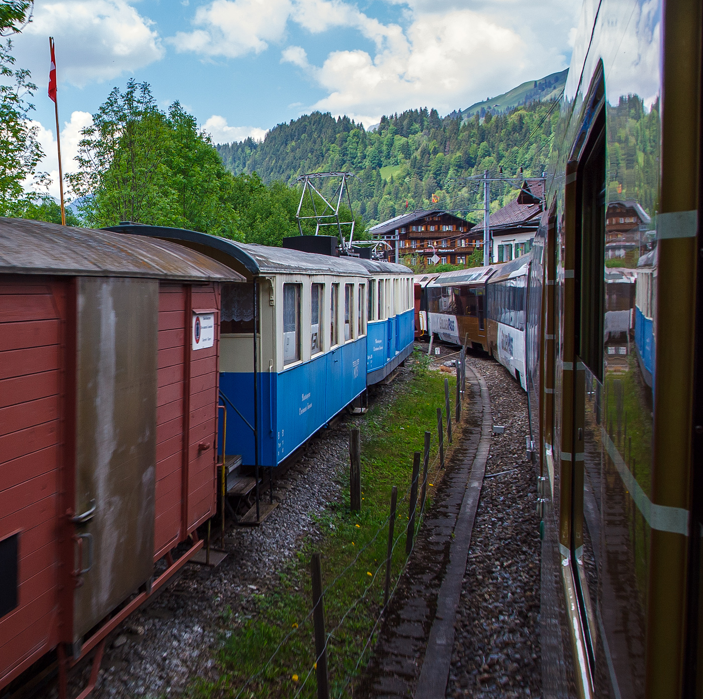 Der ehemalige Personenwagen MOB B⁴ 61 und der Triebwagen ex MOB De 4/4 26, am 28 Mai 2012 in Saanen, aufgenommen aus fahrendem Zug. Der Zug ist seit 1994  abgestellt als Vereinslokal der Modellbahngruppe Obersimmental-Saanenland (MOS). Davor noch angeschnitten der gedeckte G�terwagen ex MOB K 529.