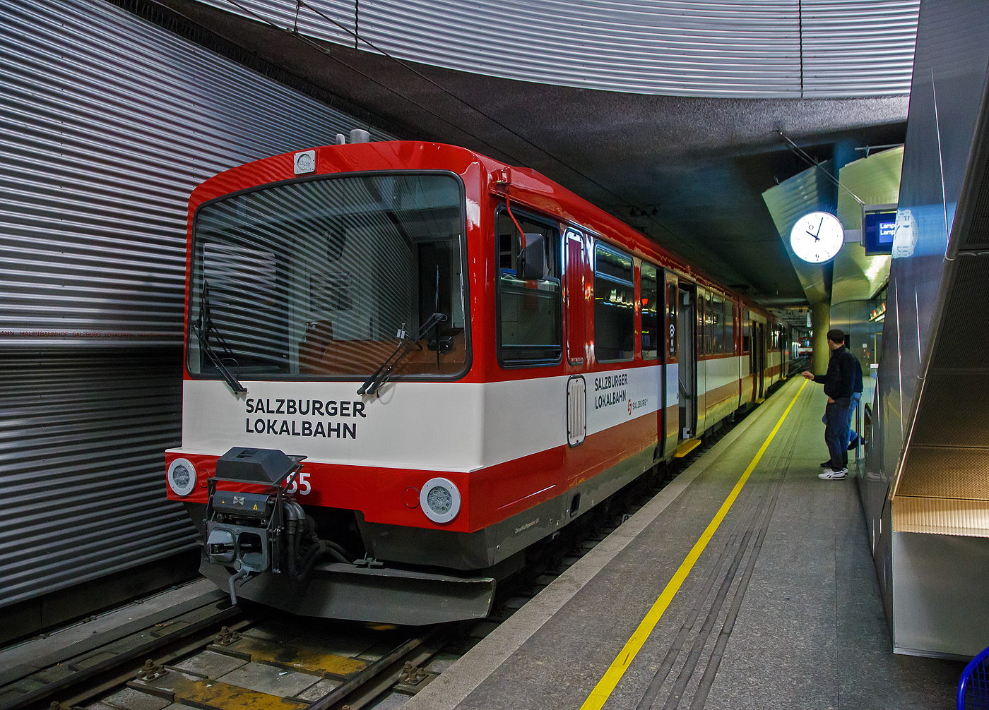 Der ET 55 „Land Salzburg“ (Baujahr 2001) der SLB - Salzburger Lokalbahn steht am 12.09.2022 im Hbf Salzburg (tief). 

Der Triebwagen wurde 2001 von Siemens (ex SGP - Simmering-Graz-Pauker AG) gebaut, der elektrische Teil ist von Bombardier (ex AEG).

Seit 1983 bestimmen die bis 2002 beschafften Stadtbahnwagen der Typenreihe ET40 (ET40HF und ET40NF) das Bild der Salzburger Lokalbahn. Diese waren nach über 30 Jahren die ersten Neufahrzeuge und setzten ein Zeichen für Aufschwung des Nahverkehrs im nördlichen Flachgau und im angrenzenden Innviertel.

Nach Abwägung mehrerer Projekte entschied sich die SLB in Anlehnung an deutsche Stadtbahnwagen sechsachsige Gelenktriebwagen zu beschaffen. So geschah es, dass 1983 der erste Triebwagen einer zunächst fünf Fahrzeuge umfassenden Lieferserie (ET41-ET45) in Salzburg eintraf und sich sofort großer Beliebtheit erfreute. Das Konzept dieser Triebwagen bewährte sich, sodass ab 1988 eine weitere Serie (ET46-ET50) in Betrieb genommen wurde. Diese Triebwagen wiesen einige Modifikationen auf, die sich jedoch äußerlich kaum bemerkbar machen.

Infolge der stetig wachsenden Fahrgastzahlen und um die letzten Altbautriebwagen aus dem Planbetrieb nehmen zu können, wurden 1992 vier Triebwagen (ET51-ET54) und 2001/02 weitere vier (ET55-ET58) ausgeliefert. Die Triebwagen ET50 bis ET58 wurden von 2012 bis 2014 mit Niederflur-Mittelteilen zu achtachsigen Fahrzeugen umgebaut. Als erstes Fahrzeug wurde ET54 im Juli 2012 nach dem Umbau durch die Firma INEKON in Ostrava (CZ) in Salzburg übernommen. 

Die beiden Wagenkästen eines Triebwagens stützen sich stirnseitig über Schraubenfedern auf die Drehgestelle ab. Diese sind als Triebdrehgestelle ausgeführt, welche je einen Gleichstrommotor aufnehmen. Die Kraftübertragung erfolgt mittels starrer Wellen und Achsgetrieben auf beide Achsen eines Drehgestells. Jede der acht Achsen ist mittels Maggy-Federn mit dem Drehgestell verbunden. Jede Achse der Triebdrehgestelle wird mit Federspeicherbremsen gebremst. Als primäre Betriebsbremse dient eine elektrische Bremse, als Zusatzbremse dienen Magnetscheibenbremsen an jedem Drehgestell. Die Laufdrehgestelle werden mit Druckluftbremsen gebremst. Durch entsprechende elektronische Ansteuerung können die Triebwagen in Vielfachsteuerung (max. drei Fahrzeuge) eingesetzt werden.

Mechanischer Teil
Der Wagenkasten ist als selbsttragende Stahlkonstruktion ausgeführt welche sich auf den beiden Motordrehgestellen an den Fahrzeugenden sowie auf Jakobs-Drehgestelle abstützt. Der Fahrmotor ist den Drehgestellen als Längsmotor eingebaut, die Kraftübertragung erfolgt über Winkelgetriebe (Tandemantrieb). Die Primärfederung wurde mittels Megi-Federn ausgeführt, zwischen Drehgestell und Wagenkasten kommen Schraubenfedern in Verbindung mit hydraulischen Stoßdämpfern zum Einsatz. Die Wagen 50–58 wurden in den Jahren 2012–2014 um ein Niederflur-Mittelteil erweitert und ein zusätzliches Jakobs-Drehgestell erweitert. Des Weiteren wurden in den Endwagen Sitze und Bodenbeläge getauscht sowie die Drehfalttüren durch Schwenkschiebetüren der Firma IFE ersetzt. Das Umbauprogramm wurde 2019 mit dem ET46 abgeschlossen. Somit sind von den 18 Triebwagen insgesamt 13 mit Mittelteil (ET46-ET58, Bezeichnung ET40NF) ausgestattet und 5 Fahrzeuge (ET41-ET45) noch wie ursprünglich 2-teilig. 

Elektrischer Teil
Die Fahrmotoren sind als vierpolige, kompensierte Vollspannungs-Reihenschlussmotoren mit 300 kW Nennleistung ausgeführt. Jeder Motor wird von einem eigenen Thyristor-Gleichstromsteller (Chopper) angesteuert. Durch die Verwendung von Gleichstromstellern ist es möglich, Bremsenergie in die Fahrleitung zurück zu speisen. Kann die Bremsenergie nicht aufgenommen werden, wird diese durch Bremswiderstände in Wärme umgewandelt. 

TECHNISCHE DATEN:
Gebaute Anzahl: 9 (ET 46 bis ET 58)
Spurweite:  1.435 mm (Normalspur)
Achsfolge:  B‘2‘2‘B‘
Länge über Puffer: 38.800 mm
Höhe mit Dachaufbauten: 3.720 mm
Breite: 2.674 mm
Fußbodenhöhe über SOK: 984 mm, im Niederflur-Mittelteil 350 mm
Leergewicht: 62.700 kg
Drehzapfenabstand: 3 x 10.400 mm
Achsstand im Drehgestell: 1.900 mm
Raddurchmesser:  780 mm (neu) / 710 mm (abgenutzt)
Kleinster zulässiger Bogenradius:  80 m
Höchstgeschwindigkeit: 80 km/h
Sitzplätze: 104
Stehplätze: 158
Leistung Fahrmotoren:  2 x 300 kW 
Übersetzung: 1:5,625
Stundenleistung:  600 kW
Fahrdrahtspannung : 1.000 V DC (=)
Steuerung:  Chopper (Gleichstromsteller)
Stromabnehmer:  Halbscherenstromabnehmer
Zug- und Stoßvorrichtung: Scharfenbergkupplung
Bremsbauart: Elektrodynamische Nutzbremse, Federspeicher-, Magnetschienen- und Solenoidbremse

Die SLB ist eine Tochtergesellschaft der Salzburg AG für Energie, Verkehr und Telekommunikation. Die Bahn nahm 1896 ihren Betrieb auf. Von 1907-1940 betrieb die Salzburger Eisenbahn und Tramway Gesellschaft (SETG) die Bahn, die in der Stadt Salzburg auch ein Straßenbahnnetz betrieb.

Quelle: SLB
