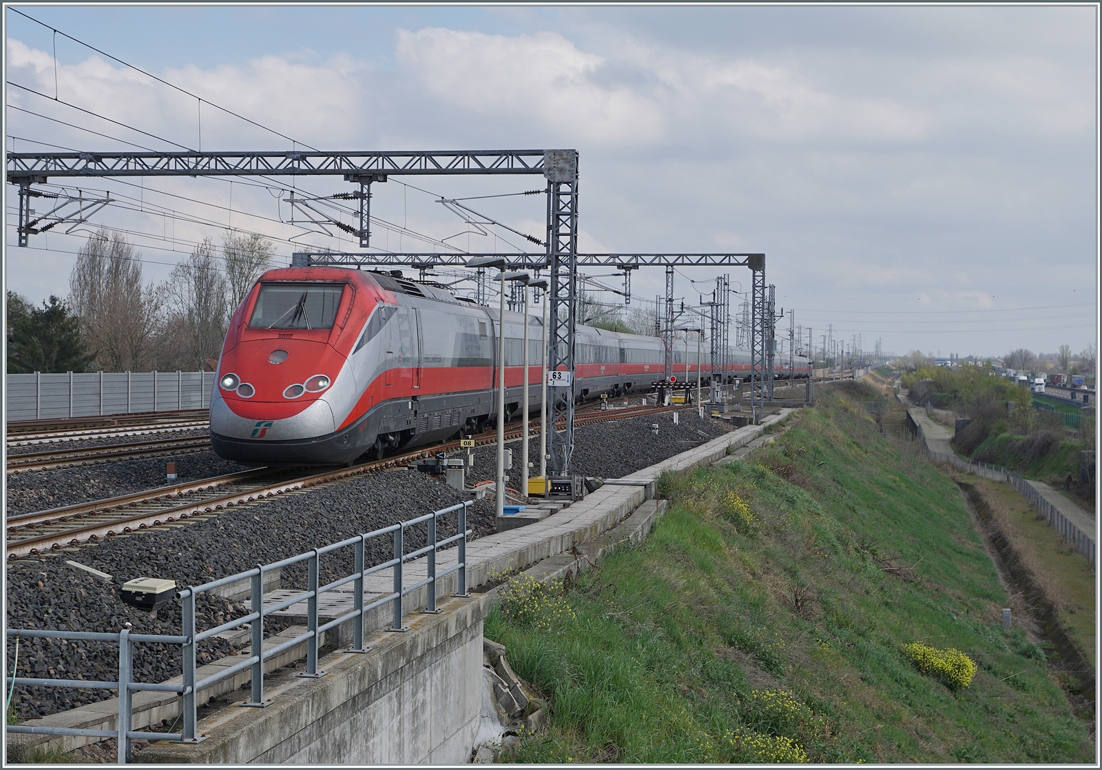 Der FS Trenitalia ETR 500 044 auf dem Weg in Richtung Milano erreicht den Bahnhof von Emilia AV, wo der Zug eine planm�ssigen Aufenthalt hat und somit die Schnellfahrweiche auf ablenkender Stellung bef�hrt um an den Bahnsteig von Gleis 4 zu gelangen. 

14. M�rz 2013

  