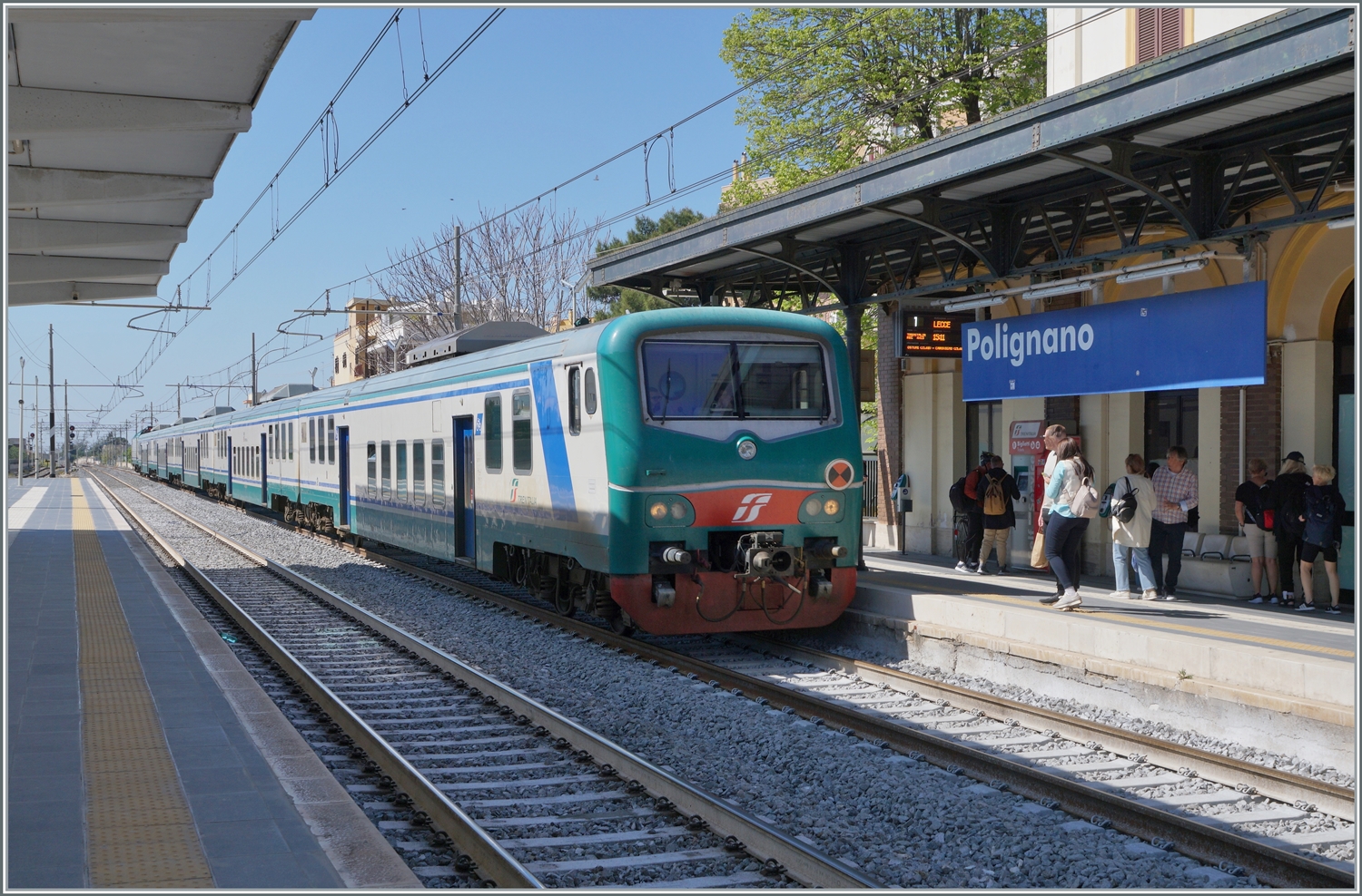 Der FS Trenitalia Regionalzug 4413 von Bari nach Lecce erreicht Polignano A Mare. Trotz der vielen neuen Fahrzeuge sind hin und wieder weiterhin �lter Z�ge im Einsatz, wo wie dieser FS Tpy 73 Niederflurzug (Carrozza vicinale a piano ribassato) in XMPR Lackierung mit einem npBD an der Spitze und vier nB Wagen sowie der schiebenden FS Trenitalia E 464 123. 

22. April 2023