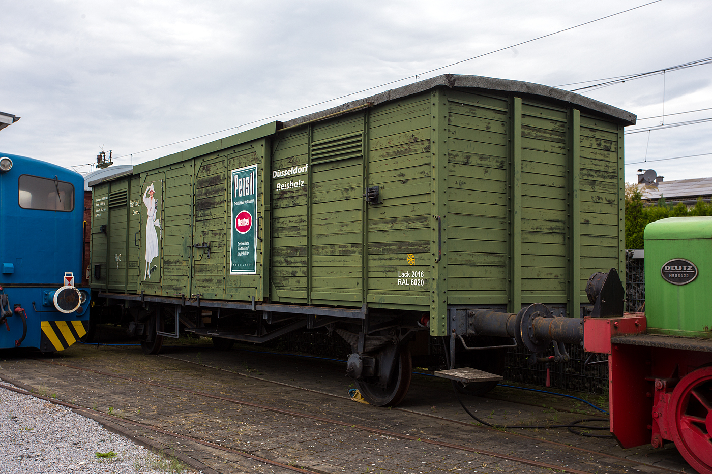 Der historische gedeckte Güterwagen H3 der Henkel & Cie. G.m.b.H. (Düsseldorf-Reisholz) vom Eisenbahn- und Heimatmuseum Erkrath-Hochdahl e.V. am 26 Mai 2024 beim Lokschuppen Hochdahl.

Ein Jahrhundert ist er alt. Schon in den 1920er Jahren setzte Henkel (seit 1975 Henkel AG & Co. KGaA) gedeckte Waggons ein, um Zwischen- und Endprodukte preisgünstig zu transportieren. 1933 waren 35 gedeckte Güterwaggons im Bestand des Unternehmens. Fritz Henkel sen. hatte sich 1899 entschieden, sein Unternehmen von Düsseldorf-Derendorf nach Reisholz zu übersiedeln, da dort eine bessere Anbindung an die Bahn bestand. Der nun restaurierte Waggon, der bei Henkel die Nummer H3 trug, war noch Ende der 60er Jahre auf dem Firmengelände im Einsatz.  Wie alt er genau ist, kann niemand mehr nachvollziehen. Mit der Nummerierung wurde erst nach dem Krieg begonnen. 

Bis zum Rollout des Waggons haben die fleißigen Helfer im Eisenbahn- und Heimatmuseum Erkrath-Hochdahl ganze Arbeit geleistet. Der Waggon wurde bis auf das Grundgerüst zerlegt. Diverse Stahlteile wurden erneuert. 50 m² Holz, einschließlich der Türen, sind erneuert worden, 10 m² Holz an den Seitenwänden konnte ausgebessert werden. Erneuert wurden auch die komplette Dachfläche, die 32 m“ misst und der Innenboden mit 28,3 m² und fast alle Schrauben. Die Schlossschrauben sind typisch im Waggonbau und im normalen Handel nicht erhältlich. Schlossschrauben, Bodenplatten und Holz für das Aufarbeiten des Waggons hat die Henkel AG & Co. KGaA für die Restaurierung gespendet.

Der Güterwagen ähnelt den Einheitsgüterwagen G 10 der Königlich Preußischen Eisenbahn-Verwaltung (KPEV), ist aber eine Sonderbauart, Maße und baulichen Details weichen ab. Damit der Waggon möglich originalgetreu aufgearbeitet wurde, hat man sich an alten Fotos orientiert. Farbe und Beschriftung sind dem Original von damals nachempfunden. In Absprache mit Henkel erfolgte die Gestaltung zusätzlich mit nostalgischen Werbemotiven, wie die berühmten Weißen Dame und dem Persil-Paket.

TECHNISCHE DATEN:
Spurweite: 1.435 mm (Normalspur)
Anzahl der Achsen: 2
Länge über Kupplung: 12.100 mm
Max. Ladegewicht: 15.000 kg
Tagfähigkeit: 17.500 kg
Ladefläche: 28,3 m²