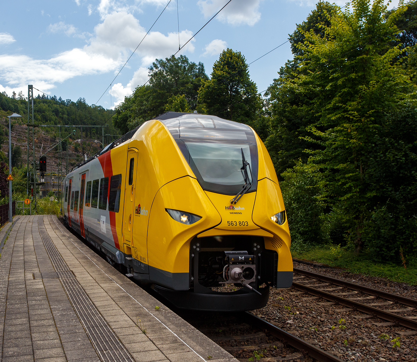 Der HLB 563 803 / 563 903 (94 80 0563 803-6 D-HEB / 94 80 0563 903-4 D-HEB), ein zweiteiliger Hybridtriebzug (E/Akku) der BR 563 vom Typ SIEMENS Mireo Plus B der HLB (Hessische Landesbahn GmbH), erreicht am 16 Juli 2025, als RB 90  Westerwald-Sieg-Bahn  (Limburg/Lahn - Westerburg - Altenkirchen/Westerwald - Au/Sieg - Betzdorf/Sieg – Siegen), den Bahnhof Kirchen/Sieg.

Der zweiteilige SIEMENS Mireo Plus B wurden 2024/25 von SIEMENS in Krefeld gebaut und im April 2025 an die HBL ausgeliefert.
