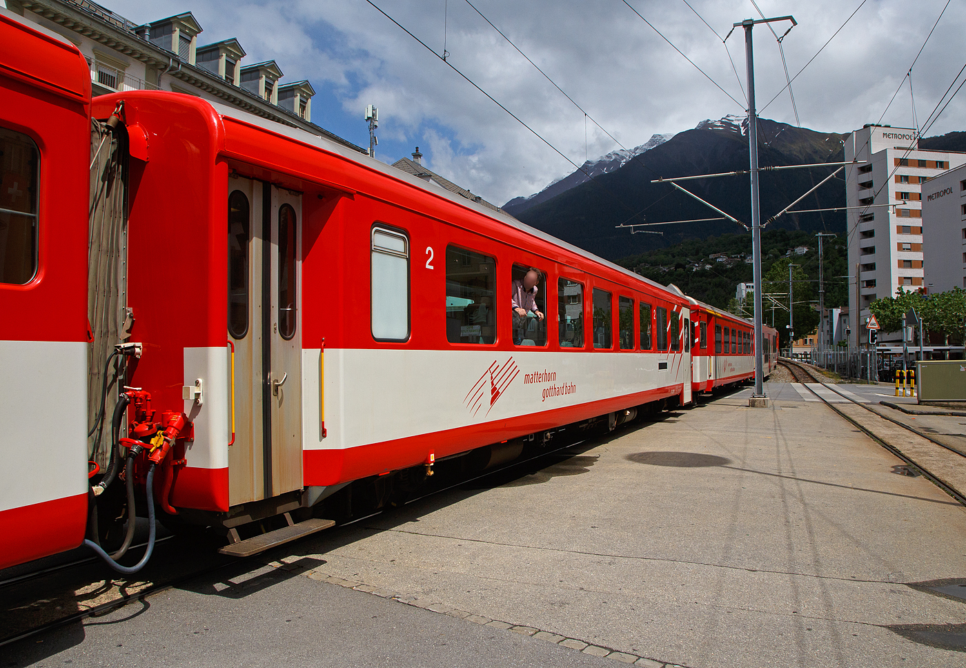 Der MGB 2. Klasse Reisezugwagen B 4254 (ein ex FO Leichtmetallwagen f�r Pendelzug) am 25.05.2023 im Zugverband in Brig.

Mit der Einf�hrung von Pendelz�gen wurde ein gro�er Schritt zur Rationalisierung des FO-Regionalverkehrs vollzogen. 1971/1972 lieferte die SIG vier dunkelrot lackierte Zuggarnituren, bestehend aus den Zahnrad-Gep�cktriebwagen Deh 4/4 I 51-55 (Triebdrehgestelle von SLM und elektrische Ausr�stung von BBC), den Zweitklasse-Wagen B 4251-4258 sowie den Steuerwagen ABt 4151-4154. Diese schmalspurigen SIG EW 1 (Einheitswagen) wurden f�r die ehemalige Furka-Oberalp-Bahn (FO) wurden verk�rzten Ausf�hrung gebaut. Bis zur Fusion der FO und der BVZ zur MGB 2003 und der Einf�hrung des Wind-Design trugen sie ein helleres Rot sowie das FO-typische wei�e Band.

TECHNISCHE DATEN:
Hersteller: SIG (Schweizerische Industrie-Gesellschaft in Neuhausen am Rheinfall)
Serie: B 4251–58 (8 St�ck), Baujahr 1971
Spurweite: 1.000 mm
L�nge �ber Puffer 17.020 mm
Drehgestelle: SIG-S mit Bremszahnrad
Eigengewicht: 13,3 t
Sitzpl�tze: 64 in der 2. Klasse 
Zul. H�chstgeschwindigkeit: 90 km/h
Zugelassen f�r Netz der: MGB und RhB
