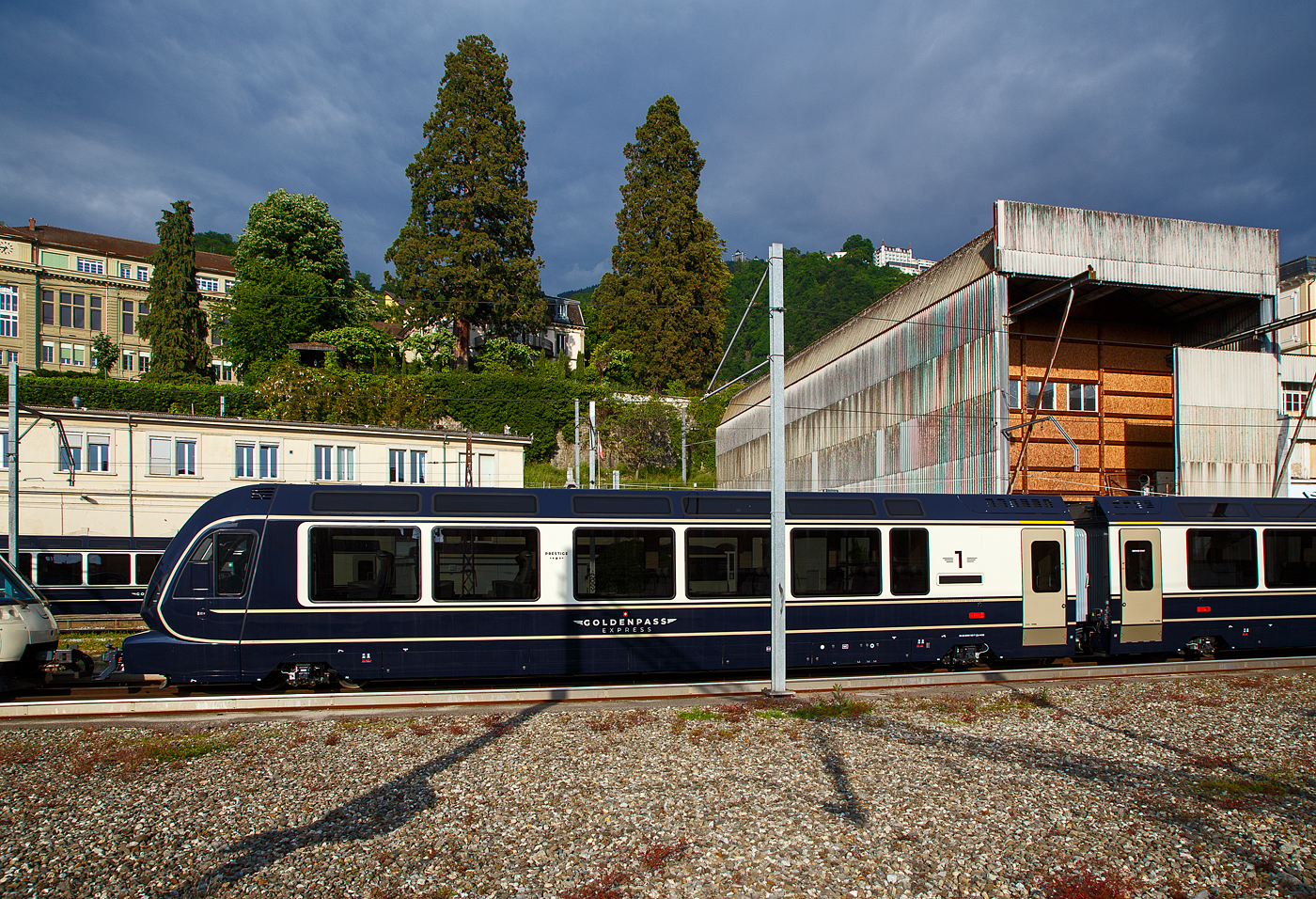 Der MOB GPX - GoldenPass Express Premium-/1.Klasse Steuerwagen Ast 183 (96 85 8300 183-7 CH-MOB) mit variablem Drehgestell (EV18) der Montreux-Berner Oberland-Bahn AG) abgestellt am 26. Mai 2023 beim Bahnhof Montreux. 

Diese Steuerwagen Ast 181 bis 184 (4 St�ck), haben jeweils 9 Sitzpl�tze mit verstellbaren/drehbaren Sitzen in der Prestige Klasse und 20 Sitzpl�tze in der 1. Klasse. Die Wagenl�nge �ber die automatische Schwab-Kupplung betr�gt 19.320 mm, das Eigengewicht eines Wagens betr�gt 27,0 t.