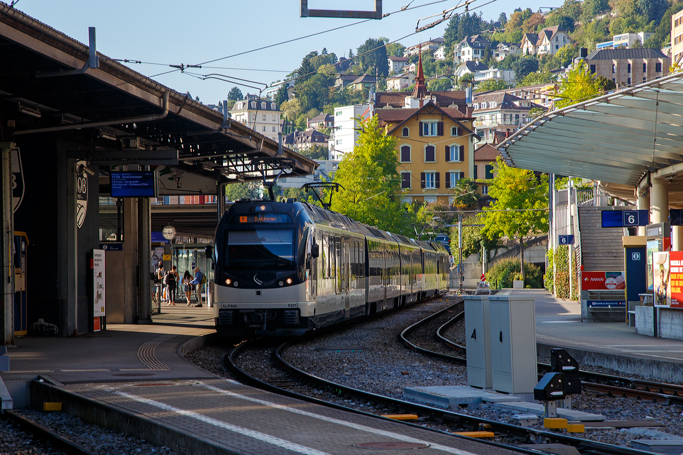Der MOB Regionalzug nach Zweisimmen steht am 10 September 2023 im Bahnhof Montreux zur Abfahrt bereit. Der Zug besteht hier aus dem MOB ALPINA 9201 bzw. Be 4/4 9201, dazwischen drei normalen (konventionellen) Personenwagen und am Schluss den MOB ALPINA 9301 bzw. ABe 4/4 9301.

Die vier von Stadler 2016 gebauten MOB Alpina-Triebzüge ABe 8/8 9000 sind modular einsetzbar. Ein Triebzug besteht jeweils aus einem Be 4/4 9200er und einem ABe 4/4 9300er Triebwagen. So können sie (wie hier mit 2) mit bis zu neun (hier 2) bestehenden Zwischenwagen ergänzt werden.

Die MOB (Montreux–Berner Oberland-Bahn) bestellt Ende 2013 diese Triebzüge bei Stadler Rail, da die ABDe 8/8 Doppeltriebwagen der Serie 4000, die lange Zeit das Rückgrat der Zugförderung auf der Strecke Montreux – Zweisimmen waren, an der Leistungsgrenze waren um den Bedürfnissen des Verkehrs gerecht zu werden. Auch die Geschwindigkeit und Beschleunigung sind unzureichend. Die neuen Triebwagen können sowohl für die Traktion von schwere Züge (bis zu 9 Wagons), sowie für Solofahrten außerhalb der Hauptverkehrszeiten, was ihre optimale Nutzung mit bis zu vier Umläufen zwischen Montreux und Zweisimmen ermöglicht. Diese dynamischen und zeitgemäßen Züge sind einladend und komfortabel für Reisende (obwohl wir wohl lieber die ABDe 8/8 4000 sehen würden). Sie reagieren technologisch auf schwierige Betriebsbedingungen, aber auch auf Erwartungen Kunden (Reisende).

Technische Merkmale:
-Wagenkasten aus Aluminium-Strangpressprofile für eine höhere Lebensdauer und leichtere Instandhaltung bei gleichzeitig geringerem Fahrzeuggewicht.
- Luftgefederte Drehgestelle sorgen für noch mehr Komfort und eine verbesserte Laufruhe
- Mehrfachtraktion mit bis zu 3 Doppeltriebwagen
- Rekuperationsbremse / dynamische und elektromagnetische Bremse
- 2 Eingänge pro Seite für einen schnellen Fahrgastwechsel
- Behindertengerechte Zugangsmöglichkeiten
- Behindertengerechtes geschlossenes WC-System

TECHNISCHE DATEN (als Triebzug ohne Zwischenwagen):
Fahrzeugbezeichnung: ABe 8/8 (ABe 4/4 + Be 4/4)
Anzahl Fahrzeuge: 4 (je 4 ABe 4/4 und Be 4/4)
Inbetriebsetzung: 2016
Spurweite: 1.000 mm
Achsanordnung: Bo’Bo’ + Bo’Bo’
Länge über Kupplung: 40.920 mm
Fahrzeugbreite: 2.650 mm
Fahrzeughöhe: 3.850 mm
Drehzapfenabstand:12.830 mm
Achsstand im Drehgestell: 2.000 mm
Treibraddurchmesser (neu): 810 mm
Höchstgeschwindigkeit: 100 km/h
Dauerleistung am Rad: 2 x 1.020 kW
Maximalleistung am Rad: 2 x 1.400 kW
Anfahrzugkraft: 300 kN (bis 35 km/h)
Speisespannung: 960 V DC (Gleichstrom)
Maximale Anfahrtsbeschleunigung: 1,2 m/s²
Maximale Bremsverzögerung: 1,33 m/s²
Kleister befahrbarer Gleisbogen: R = 47 m
Sitzplätze: 1. Klasse 18 / 2. Klasse 55 und 8 Klappsitze
Stehplätze (4 Pers./m²): 125
Fußbodenhöhe: Niederflur 400 mm / Hochflur 1.040 mm
Einstiegbreite: 1.300 mm
Kasten-Längsdruckkraft: 800 kN

Quelle: Stadler Rail (französisch)