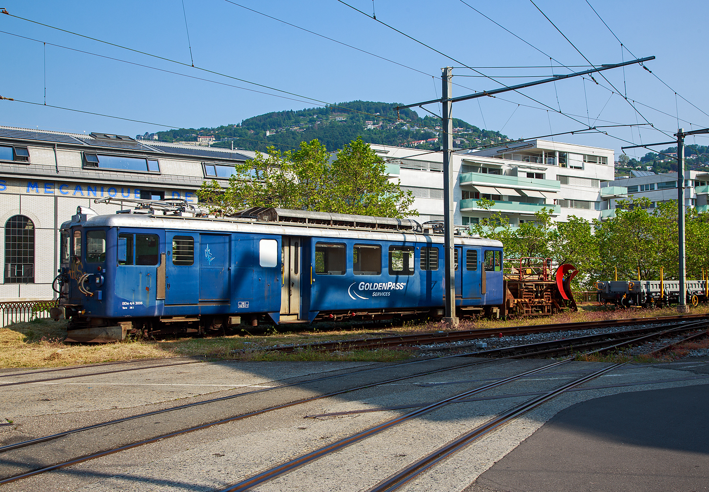 Der MOB Triebwagen BDe 4/4 3006  GoldenPass Services  mit dem vorgestellten MOB Schneepflug X 12 wartet am 28. Mai 2023 in Vevey noch auf Schnee.

Der Triebwagen wurden 1946 von SIG / BBC / MOB gebaut und als CFe 4/4 3006 in Betrieb genommen, Umzeichnungen erfolgten 1956 in BFe 4/4 und 1962 in BDe 4/4. Im Jahr 1986 wurde die F�hrerstands Einrichtung (Seite Montreux) ausgebaut (Einbau in den Steuerwagen Ast 117). 1997 ging er zum Baudienst, 2007 wurde ein Personalabteil und in den ehemaligen Gep�ckabteilen wurden je eine Laufschiene f�r eine Krankatze eingebaut. Diese erlauben das Be- und Entladen von Baudienstmaterial. Zwischen 1997 und 2015 war der Triebwagen mit st�ndig mit dem BDe 4/4 3005 (als Paar) gekuppelt, siehe http://hellertal.startbilder.de/bild/schweiz~privatbahnen~mob-montreuxa8211berner-oberland-bahn/718793/die-mob-triebwagen-bde-44-3006.html
Im Jahr 2015 erhielten beide Triebwagen wieder einen 2. F�hrerstand und k�nnen so wieder einzeln fahren. Zudem erfolgte ein Einbau von Rechteckscheinwerfer an beiden Stirnfronten.

TECHNISCHE DATEN:
Spurweite: 1.000 mm (Meterspur)
Achsformel: Bo’Bo’
L�nge �ber Puffer: 16.620 mm
L�nge des Kastens: 15.620 mm
Drehzapfenabstand: 11.350 mm
Achsabstand im Drehgestell: 2.450 mm
Triebraddurchmesser: 850 mm (neu)
H�he: 3.600 mm
Breite: 2.700 mm
Stundenleistung: 463 kW
Stundenzugkraft : 5,10 t
�bersetzung: 1:5,67
H�chstgeschwindigkeit: 75 km/h
Eigengewicht: 36 t
Ladefl�che: 12,4 m�
Zuladungsgewicht: 4,0 t
Bremsen: Hs / V / C / Cr / X
