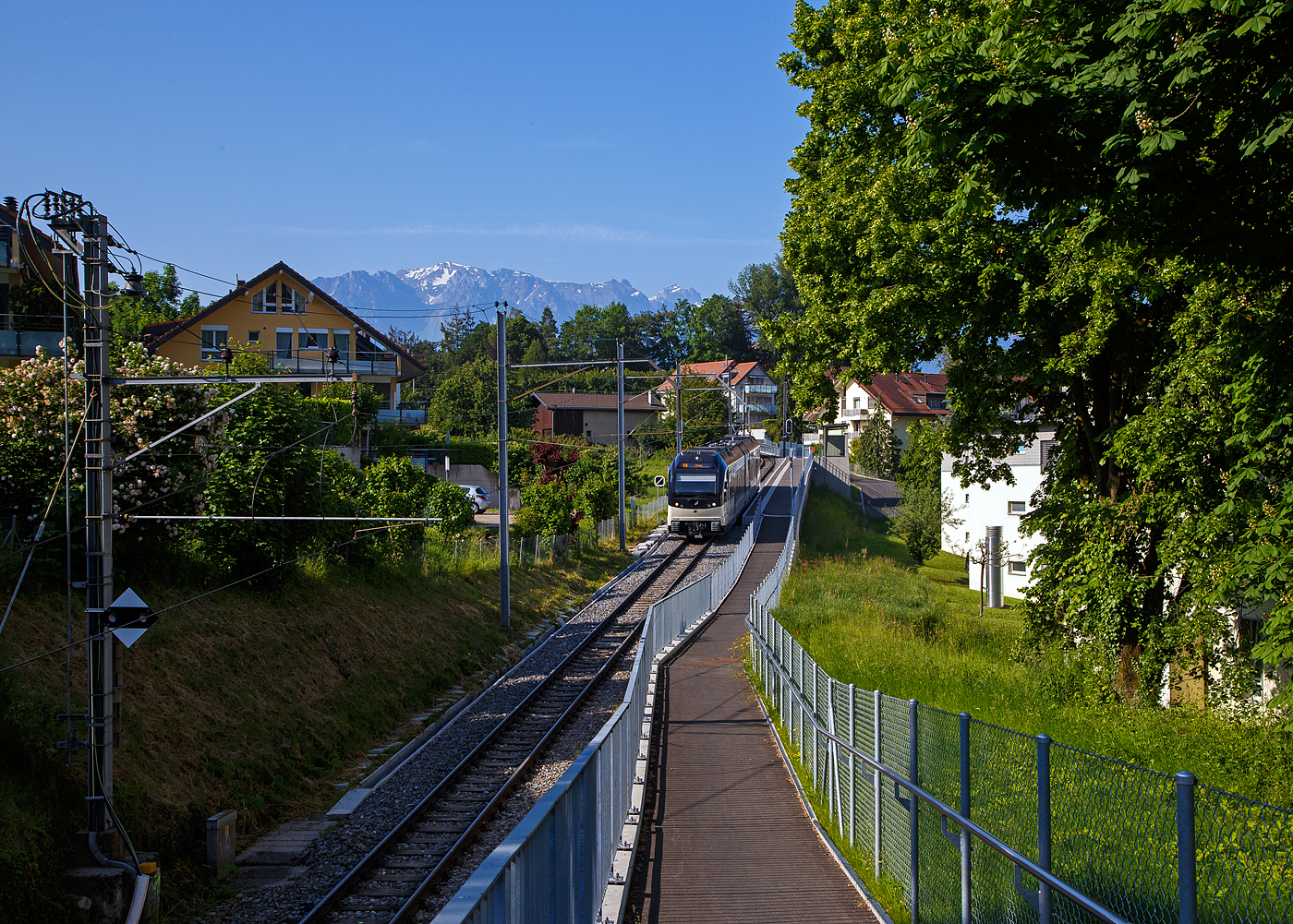 Der MVR (ex CEV) SURF ABeh 2/6 7501  Saint-Légier-La Chiésa , als R /(Regionalzug) von Blonay nach Vevey, fährt am 27.05. 2023 ohne Halt durch die neue Bedarfshaltestelle Vevey Vignerons, welche leider die beiden Haltestellen Clies und Gilamont ablöst hat.

SURF steht für Série Unifiée Romande pour Réseau Ferré métrique (Einheitliche Serie für das Westschweizer Meterspurige Schienennetz). Diese ab 2015 gebaute meterspurige Triebzüge mit gemischtem Adhäsions- und Zahnradbetrieb gehören zu den Stadler GTW der 4. Generation.