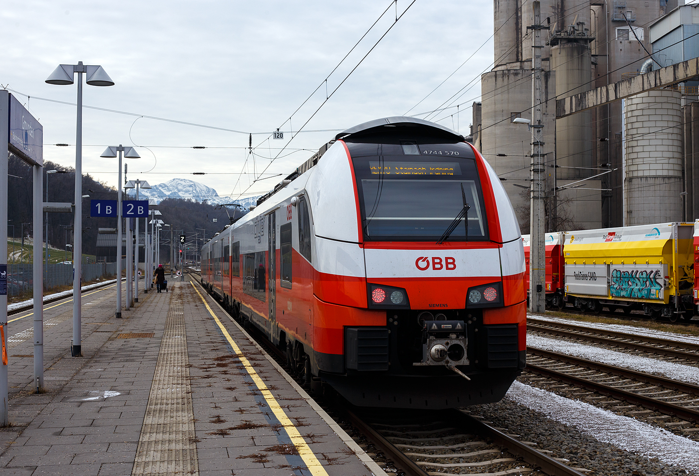 Der ÖBB „Cityjet“ 4744 070 / 7044 070 / 4744 570 „Austrian Spirit“ verlässt am 14 Januar 2025, als REX 70 (3418), von Linz Hbf über Attnang-Puchheim und Bad Ischl nach Stainach-Irdning, den Bahnhof Gmunden. Rechts das Zementwerk Hatschek in Gmunden der Rohrdorfer Zement GmbH