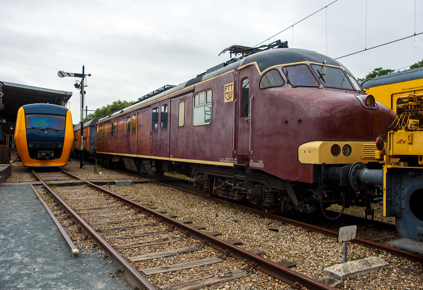 Der Posttriebwagen/Motorpost mP 3031 (Plan mP Serie 3000), ein speziell für den Posttransport konzipierter Elektrotriebwagen, am 24 Juni 2025 im Het Spoorwegmuseum (bis 2005 NSM - Nederlands Spoorwegmuseum / Niederländischen Eisenbahnmuseum) in Utrecht im ehemaligen Bahnhof Maliebaan. Ein sehr schönes Eisenbahnmuseum das zum Verweilen einlädt.

Der elektrische Posttriebwagen/Motorpostwagen der Baureihe mP 3001–3035 wurde 1966 von Werkspoor N.V. in Utrecht gebaut und an die PTT (Staatsbedrijf der Posterijen, Telegrafie en Telefonie / niederländische Post) geliefert und bei der NS - Nederlandse Spoorwegen (Niederländischen Staatsbahnen) eingestellt. 

Vorgeschichte:
Ab 1956 wurden 25 Mat '24 Elektotriebwagen -  Blokkendozen  (Kastendose) aus den Jahren 1926–1930, die zuvor im Personenverkehr eingesetzt worden waren, versuchsweise zu Motorpostwagen der Serie mP 9200 umgebaut. Dadurch sollten die durch den Posttransport verursachten Störungen im Personenverkehr reduziert werden. Nach dem erfolgreichen Versuch wurde 1963 die Anschaffung neuer Motorpostwagen beschlossen. In den Jahren 1965 und 1966 trafen 35 ein, die als Baureihe Plan mP Serie 3000 (PTT mP 3001–3035) eingereiht wurden. 

Sie boten eine Grundfläche von 41 m² und eine Ladekapazität von 15 Tonnen. Auf beiden Seiten waren drei große Schiebetüren zum Be- und Entladen der Rollbehälter mit Postsäcken angebracht. Es gab auch einen kleinen Sortierbereich. Die Anhängelast der Motorwagen reichte aus, um 200 Tonnen zu ziehen. So konnten sie vier beladene Postwagen oder acht Güterwagen ziehen. Die Hauptfarbe war Braun, wie die Farbe der Güterwagen. 1975 wurde ein größerer Teil der Front gelb lackiert.

Im Jahr 1978 wurden 60 speziellen Postgüterwagen der Nummern 2422 000–063 der Gattung Hbbkkss angeschafft um den Postverkehr völlig unabhängig vom Personenverkehr abwickeln zu können. Sie waren jedoch nicht braun, sondern rot lackiert. Die gezogenen und stromlinienförmigen Postwagen wurden ausgemustert. Das Museum besitzt auch den P 7920 bzw. den stromlinienförmigen P 8502. Ab 1982 wurden die Motorpostwagen in PTT-Rot lackiert, um besser zu den ebenfalls roten Postwagen zu passen.

Die Motorpostwagen wurden im Auftrag der PTT durch die NS (Niederländische Eisenbahn) gewartet und von Lokführer der NS gefahren.

Technik:
Die Triebwagen sind 26.400 m lang, 2.760 m breit und 3.800 m über den Schienen hoch. Das Gesamtgewicht beträgt 55 Tonnen. Dank der vier Achsen beträgt die Achslast 13,75 Tonnen. Jede Achse ist mit einem Fahrmotor vom Typ Smit-Heemaf ausgestattet. Jeder Motor hat eine Leistung von 138 kW (188 PS). Die Gesamtleistung des Triebwagens beträgt so 552 kW (752 PS). Dies entspricht dem Antriebssystem eines Triebwagens der Baureihe Plan V. Daher verfügen die Triebwagen über eine sehr hohe Beschleunigung. Ein leerer Triebwagen beschleunigt in 55 Sekunden auf 125 km/h. Die höchstzulässige Geschwindigkeit betrug 140 km/h. Die Triebwagen sind mit zwei Westinghouse-Kompressoren mit einer Kapazität von 280 l/min ausgestattet. Auf dem Dach sind zwei Faiveley AM 30-Stromabnehmer mit Doppelschleifstücken montiert. Die Achsfolge ist Bo'Bo'. 

Aufbau:
Der Führerstandaufbau ist nahezu identisch mit dem der Triebwagen der Baureihen V und T. Der einzige Unterschied besteht darin, dass sich neben der rechten Führerstandstür ein zusätzlicher Rangierführerstand befindet. In Führerstand I befindet sich mittig an der Rückwand eine Tür zum Zugführerabteil. In Führerstand II bietet diese Tür Zugang zum großen Ladebereich mit vier Ladetüren auf jeder Seite. Auch das Zugführerabteil ist vom Ladebereich aus zugänglich. Auch eine Toilette ist im Triebwagen vorhanden.

Die Motoren sind in einer Aufhängung montiert. Der Fahrmotor ist einseitig rollengelagert auf der Achse gelagert. Die Motorachse wird von einem Ritzel angetrieben, das mit einem festen Zahnrad auf der Radachse kämmt. Durch die Verwendung von Rollenlagern anstelle von Gleitlagern konnte die Anzahl überhitzter Lagerstellem erheblich reduziert werden. Der Triebwagen ist für eine Geschwindigkeit von 140 km/h ausgelegt. Unter dem Waggon befinden sich zwei Kompressoren. Diese können 280 Liter Luft pro Minute liefern. Diese Luft wird für die elektropneumatischen Bremsen und verschiedene elektropneumatische Geräte verwendet. Zur Stromversorgung des Steuerkreises und der Beleuchtung ist unter dem Waggon ein Heemaf-Motorgenerator installiert. Dieser wandelt die 1.500 Volt Oberleitungsspannung in 100 Volt für den Steuerkreis und 145 Volt für die Beleuchtung um. Der Motorgenerator hat eine Leistung von 5 kW. Die Schaltschränke und Relaiskästen befinden sich unter dem Waggon. An die Motorwagen können maximal drei beladene Postwagen gekuppelt werden. Die Drehgestelle basieren auf denen der Pläne T und V, haben jedoch einen um 250 mm größeren Radstand von 3.000 mm.

Im Gegensatz zum den Mat '64 mit ihren Scharfenberg-Kupplungen, verfügen die mP 3000 über konventionelle Schraubenkupplungen und Puffer, die das Ankuppeln an Postwagen der Baureihen Plan C, Plan E und Plan L sowie an Güterwagen ermöglichten. Bis zu drei mPs konnten in Mehrfachtraktion gefahren werden. Die Postmotorwagen waren zunächst wie die alten Blokkendoos-Motorwagen rotbraun lackiert.

TECHNISCHE DATEN:
Gebaute Anzahl: 35
Nummerierung: mP 3001 bis 3035
Eigentümer/Betreiber: PTT / NS
Hersteller: Werkspoor N.V., Utrecht
Baujahre: 1965/66	
Ausmusterung: 1995 bis 2008
Spurweite: 1.435 mm (Normalspur)
Achsfolge: Bo'Bo' 
Länge über Kupplung: 26.400 mm
Breite: 2.760 mm
Höhe über SO: 3.800 mm
Drehzapfenabstand: 18.350 mm
Achsabstand im Drehgestell: 3.000 mm
Treibraddurchmesser: 950 mm (neu)
Leergewicht: 52 t 
Höchstgeschwindigkeit: 140 km/h (im Plandienst 125 km/h)
Motorentyp: 4 Stück vom Typ Smit-Heemaf TM 671 á 138 kW (188 PS)
Stundenleistung: 552 kW (752 PS)
Dauerleistung: 488 kW / (663 PS)
Stromsystem: 1,5 kV Gleichstrom
Stromabnehmer: 2 Stück Faiveley Typ AM 30
Anzahl der Sitzplätze: 2
Max. Zuladung: 15 t (Post)

Der niederländische Postverkehr:
Gleichzeitig mit dem Ausbau des Autopostnetzes entstand auch das sogenannte Sternnetz. Utrecht diente als Knotenpunkt für alle Post-Züge der elf verschiedenen PTT-Versandstellen. Die Einrichtung dieser Knotenpunkte ermöglichte eine bessere Konzentration des Postverkehrs. Täglich fuhren Postzüge von Amsterdam, Haarlem, Zwolle, Leeuwarden, Groningen, Arnheim, ’s-Hertogenbosch, Den Haag, Roosendaal, Rotterdam und Sittard nach Utrecht, um dort in einen Postzug mit neuem Ziel umgeladen zu werden oder Rollcontainer mit Post in Säcken oder Paketen auszutauschen. Ziel war es, möglichst wenige Container umzuladen. Zusätzlich zum Sternnetz gab es das sogenannte Randstad-Netz zwischen Rotterdam, Den Haag, Haarlem und Amsterdam. Pro Tag fanden insgesamt fünf Umläufe statt, einer morgens, einer nachmittags, zwei abends und der letzte nachts. Auch samstags und sonntags nachts fanden Umläufe statt. Lkw´s lieferten die Post zu und von den Versandzentren. Auch Deventer und Eindhoven verfügten über ein kleines Versandzentrum, das jedoch optional betrieben wurde.

Die meisten Poststationen befanden sich in der Nähe der Hauptbahnhöfe der genannten Städte und waren mit einem Sortierzentrum und manchmal sogar einem Postamt ausgestattet.

Einstellung des Postverkehrs per Bahn:
1992 wurde der erste PTT Motorpost Triebwagen an die Niederländische Eisenbahn (NS) übergeben. Der mP 3032 wurde zu einem ATB-Messwagen umgebaut und ersetzte den Messwagen „Jules“, der aus Mat '24 umgebaut worden war. Der mP 3032 erhielt den Spitznamen „mP Jules“. Später wurde das Messunternehmen aus der NS ausgegliedert und der Messwagen an Eurailscout übergeben.

1995 erwarb die NS erneut mehrere Triebwagen von der Niederländischen Post (PTT). Diese dienten dem Transport von Material und Ausrüstung zwischen den verschiedenen Werkstätten. Ab Mai 1997 wurde der gesamte Postverkehr per Bahn in den Niederlanden eingestellt. Die letzten überzähligen Triebwagen wurden daraufhin an NS Cargo verkauft. Auch diese ehemaligen Triebwagen wurden hauptsächlich für den Transport zwischen den Werkstätten und einigen anderen leichten Güterzügen eingesetzt. Geplant war außerdem der Transport von Blumen zwischen Groningen und Hoofddorp. Diese Pläne wurden nie umgesetzt, und der Transport zwischen den Werkstätten über ein eigens dafür konzipiertes Sternnetz wurde bald eingestellt.

Danach wurden die meisten ehemaligen Triebwagen außer Betrieb genommen und abgebrochen. Verwertbare Teile wurden anschließend für die Züge von Mat '64 eingelagert. Zwei Triebwagen (mP 3027 und mP 3030) blieben als Laufwagen für verschiedene leichte Verbindungen und für Übungsfahrten im Einsatz.

Vier Triebwagen (mP 3024, mP 3029, mP 3033 und mP 3034) wurden zu Messwagen für ERTMS umgebaut. Nach diesen von Railion und ProRail in Auftrag gegebenen Messungen wurden mP 3024 und mP 3029 an Eurailscout übergeben. Der mP 3024 wurde zum Messwagen „mP Jim“ umgebaut, und mP 3029 diente als Ersatzteilspender. Die Triebwagen 3027, 3030, 3033 und 3034 wurden 2009 verschrottet. Der mP 3029 wurde Ende 2019 von der Stichting 2454 CREW übernommen.

Museale Erhaltung:
Der Triebwagen (mP 3031) wurde der Sammlung des Niederländischen Eisenbahnmuseums in Utrecht hinzugefügt. Er wurde in der Farbe Rotbraun neu lackiert, die er bei seiner Auslieferung hatte. Der Postwagen Hbbkkss 242 2 043 ist ebenfalls Teil der Sammlung.

Die Stadskanaal Rail Foundation in Stadskanaal besaß den Postwagen Hbbkkss 242 2 019. Dieser Wagen wurde 2023 an die 2454 CREW Foundation übergeben. Nachdem mP 3029 Ende 2019 von der 2454 CREW Foundation erworben wurde, wurde er im ehemaligen Lokschuppen in Roosendaal restauriert. Er wurde in der rot-gelben PTT-Lackierung der 1990er Jahre, mit Beschriftung und ohne NS-Logos, wieder fahrbereit gemacht und am 16. Februar 2021 an das SSN-Gelände geliefert. Er kann besichtigt werden.

Quellen: Somda RailWiki.nl, Het Spoorwegmuseum, nmld.nl, Anschriften, Wikipedia (Niederlande) 
Stand/Überarbeitung: September 2025
