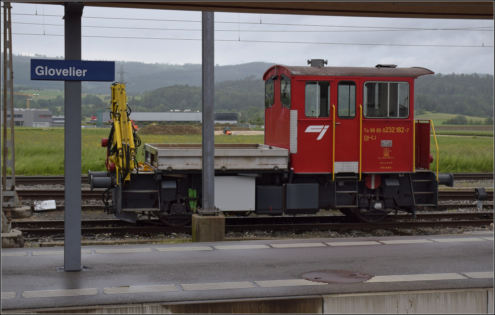 Der Rangiertraktor Tm 232 182 der CJ steht am normalspurigen Ende der Rollschemelanlage in Glovelier. Mai 2024.