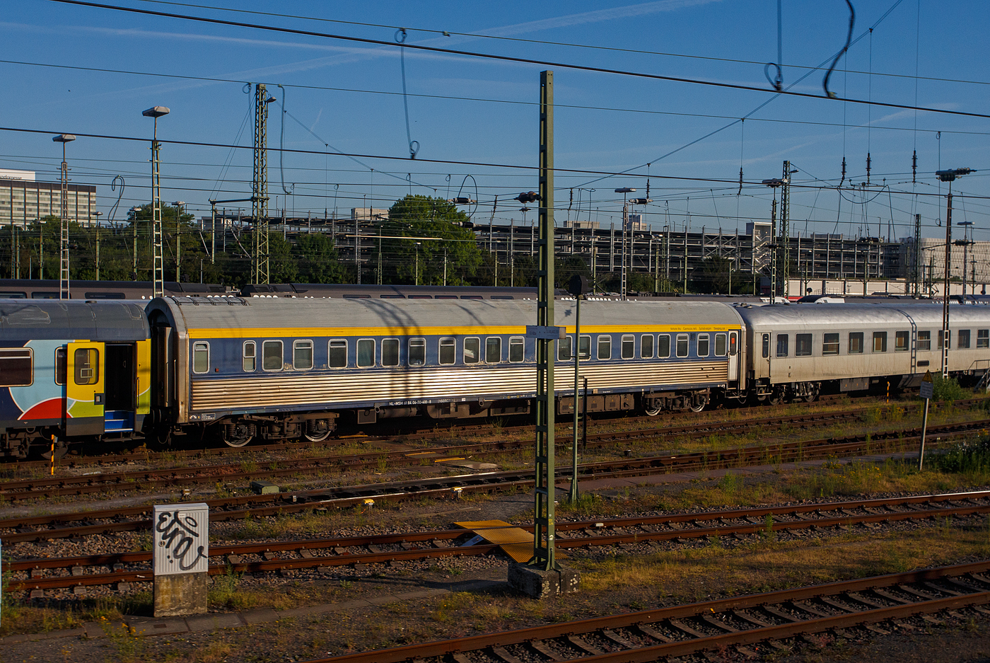 Der Schlafwagen der Gattung WLAB (ex CIWL 4536, Typ WL AB30, ex WL P), NL-MSM 61 84 06-70 418-8, der MSM Gruppe Inh. Niko Maedge e.K. (Köln) abgestellt am 20 Mai 2025 im Zugverband in Köln-Deutzerfeld, aus einem Zug heraus fotografiert, leider mit einem Mast davor.

Der Wagen wurde 1955 von der französischen Firma Etablissements Carel Fouché & Cie. (Le Mans) gebaut und als CIWL 4536 an die Compagnie Internationale des Wagons-Lits (CIWL), seit 1967 Compagnie Internationale des Wagons-Lits et du Tourisme (CIWLT, deutsch Internationale Schlafwagen- und Touristik-Gesellschaft), geliefert. Die CIWL/CIWLT ist das älteste europäische Unternehmen zum Betrieb von Schlafwagen, Speisewagen und Luxuszügen.

Der Wagen hatte folgende Bezeichnungen:
Ab 1955 - CIWL 4536 (Typ WL AB30, ex WL P)
CIWLT 51 66 06-50 036-6
SNCF 61 87 75-41 726-3
Ab 1992 - NS 71 84 70-70 018-5
NS 61 84 70-70 418-9
Ab 2004 - NL- EETC 61 84 70-70 418-9
Ab 2006 - NL- EETC 61 84 06-70 418-8
Ab 2016 - NL-MSM 61 84 06-70 418-8 (vermutlich 1922 verkauft an Train Rental GmbH (TC) 

Der Wagenursprung:
Der Typ P der Compagnie Internationale des Wagon-Lits (CIWL) war eine Schlafwagen-Type mit Außenhaut aus blankem Edelstahl. Sie wurden in Lizenz von Budd nach amerikanischem Vorbild hergestellt. Das an die französischen INOX-Wagen erinnernde Aussehen in blankem Metall blieb beim sonst von der Farbe Blau dominierten Fahrzeugpark der CIWL einzigartig.

Insgesamt 80 Wagen wurden 1955 von den Unternehmen Le Brugeoise et Nivelles, Ansaldo, Carel & Fouché sowie Fiat Ferroviaria gebaut. Sie erhielten die laufenden Nummern 4501 bis 4580. Die Wagen besaßen 20 ineinander verschachtelte Einzelabteile der „Spezial-Klasse“ nach Vorbild der amerikanischen „Double-Roomettes“, wobei die Frequenz dieser in Europa unbekannten Einzelabteile von Beginn an sehr zu wünschen übrigließ. Um 1970 wurden die Wagen von Faltenbalg- auf Gummiwulst-Übergänge umgebaut.

Nach der Übernahme des CIWL-Fuhrparks in den Besitz der jeweiligen Staatsbahnen bzw. durch Trans-Euro-Nacht wurden in den Jahren 1992 bis 1994 im RSI-Werk Ostende 20 Fahrzeuge für die ÖBB, die Nederlandse Spoorwegen sowie die Belgischen Staatsbahnen umfassend umgebaut. Dabei entstanden aus 20 Einbettabteilen 10 geräumige Dreibettabteile mit Waschbecken, Tisch und Sessel; die relativ engen Toilettenräume und das Dienstabteil am Ende ohne Einstieg blieben bestehen. Die Klimaanlagen wurden erneuert. Die Wagen erhielten Schlingerdämpfern, sowie neue Drehgestelle (Schlieren-Drehgestelle Typ 27 anstelle der Schlieren Typ N), so wurde die Höchstgeschwindigkeit auf 160 km/h gesteigert. Das Innenraumdesign wurde in Pastelltönen und die Farbgebung mit kobaltblauem Fensterband und gelbem Begleitstreifen darüber wurde neugestaltet. Die Kosten für die Renovierung beliefen sich auf 1,7 Millionen Gulden (heute ca. 765.000 Euro) pro Waggon.

Die NS und SNCB betrieben je fünf Wagen bis 2003 und beendeten dann beide den Betrieb eigener Schlaf- und Liegewagen. Die NS-Wagen gingen zunächst an Euro-Express Treincharter, die SNCB-Wagen an TTC, beide Unternehmen setzten sie in saisonalen Urlaubszügen ein. Die ÖBB schieden die letzten Wagen im Jahr 2017 aus.

Heute (2023) werden die verbleibenden Wagen bei TRI Train Rental, Euro-Express Sonderzüge und der MSM-Gruppe in Urlaubszügen eingesetzt (teilweise als Ersatzteilspender). 

TECHNISCHE DATEN (nach Umbau):
Gebaute Anzahl: 80
Baujahre: ab 1955
Spurweite: 1.435 mm (Normalspur)
Länge über Puffer: 24.050 mm
Länge Wagenkasten: 22.748 mm
Drehzapfenabstand: 16.500 mm
Drehgestelltype: Schlieren 27 (zuvor Schlieren N)
Breite: 2.865 mm
Höhe über SOK: 4.248 mm
Leergewicht: 48,5 t
Höchstgeschwindigkeit: 160 km/h
Abteile: 10 (für 1, 2 oder 3 Passagiere)
Dienstabteil: 1
Toiletten: 2