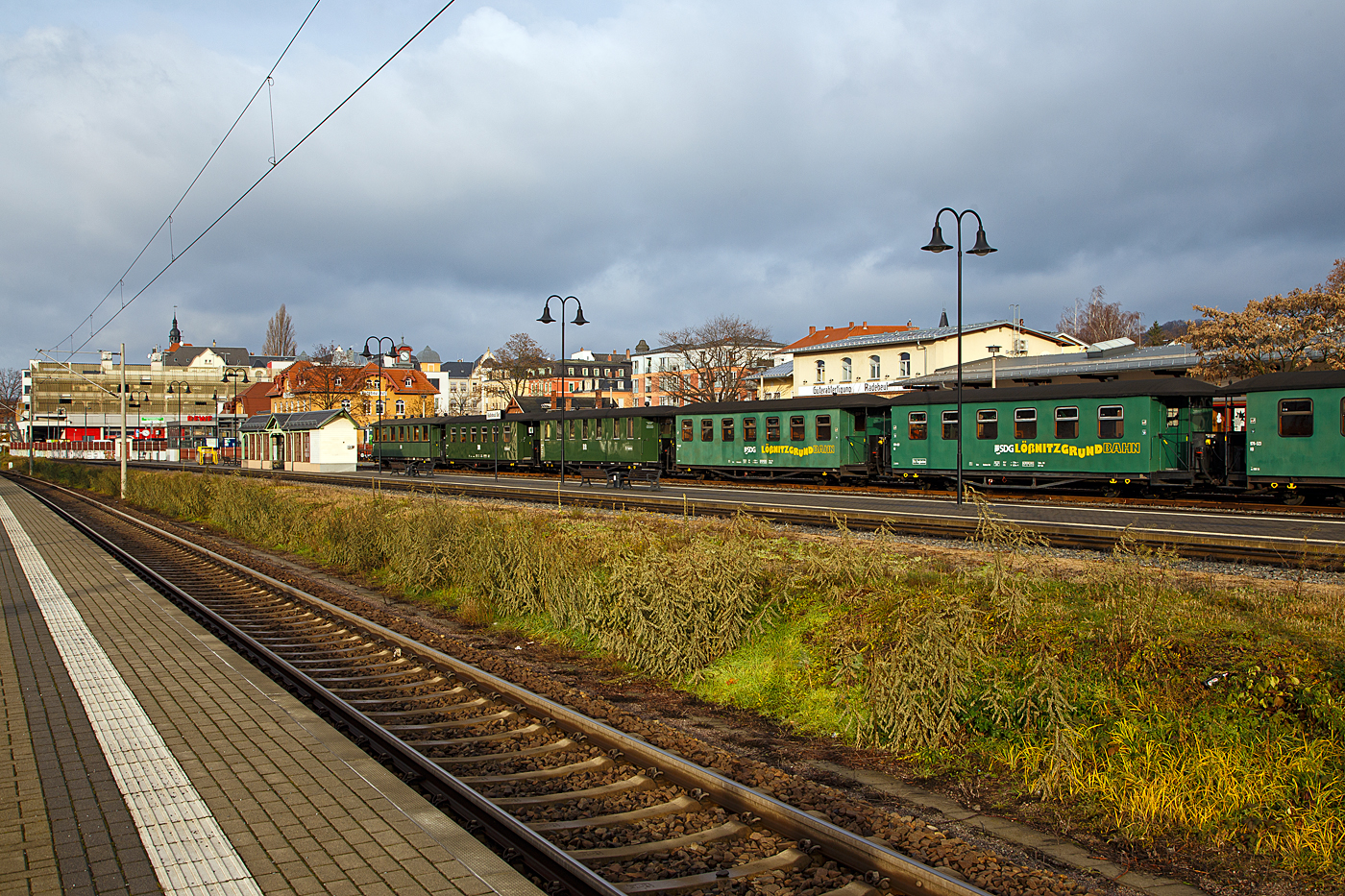 Der Schmalspur-Bahnhof Radebeul Ost (L��nitzgrundbahn) der SDG - S�chsische Dampfeisenbahngesellschaft mbH am 07.12.2022, auf Gleis 3 stehen einige vierachsiger 750 mm-Schmalspur Personenwagen. Mit der 750 mm Schmalspurbahn, kann man mit Dampfz�gen die 16,5 km lange Strecke von Radebeul Ost �ber Moritzburg nach Radeburg fahren.

Wobei nach der deutschen Wiedervereinigung und der folgenden Bahnreform, die Deutschen Bundesbahn und Deutsche Reichsbahn wurden zum 01. Januar 1994 zur Deutsche Bahn AG vereinigt, geh�rten  Bahnhof und die Schmalspur Bahn, bis Juni 2004 zur DB AG. Im Juni 2004 ging die Strecke gemeinsam mit der Wei�eritztalbahn an die BVO Bahn GmbH (seit 2007 dann SDG - S�chsische Dampfeisenbahngesellschaft). Die SDG geh�rt seit Anfang 2019 den Verkehrsverb�nden Mittelsachsen (VMS) 1/3 und Oberelbe (VVO) 2/3.