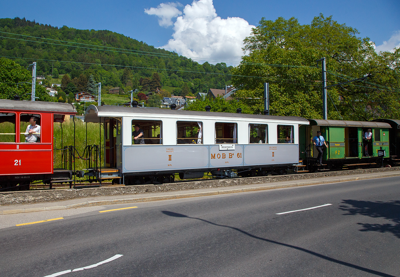 Der schmalspurige vierachsige zweite Klasse Personenwagen mit zwei Plattformen MOB B⁴ 61 seit 2016 als Geschenk von der Modellbahngruppe Obersimmental-Saanenland (MOS) bei der Museumsbahn Blonay–Chamby hier am 27 Mai 2023 im Zugverband eines BC Zuges in Blonay.

Der Wagen wurde 1906 SIG (Schweizerische Industriegesellschaft) in Neuhausen am Rheinfall als B⁴ 61 für die MOB (Montreux-Berner Oberland-Bahn) gebaut. 

Die beiden Wagen B⁴ 61 und B⁴ 62, die keine Toilette aufwiesen, wurden zusammen mit den Personenwagen BC⁴  23–26 beschafft. Grund war die Aufnahme des durchgehenden Betriebs auf der Strecke Montreux–Zweisimmen im Jahr 1905. Zudem wurden die Prognosen zur Zahl der Reisenden übertroffen. Nachdem die MOB anfänglich für die Reisezüge Drehgestell-Wagen beschafft hatte, folgten aus Kostengründen Zweiachser. Infolge von Reklamationen wechselte die MOB wiederum auf Drehgestell-Wagen, wobei es dann auch blieb.

Geschichte:
Ab 1901 in mehreren Etappen in Betrieb genommen, erreichte die Linie der Montreux-Berner Oberland (MOB) 1905 Zweisimmen. Neben der Erschließung durchquerte sie auch die bis dahin schwer zugänglichen Gebiete, insbesondere das kleine Dorf Gstaad. Das landwirtschaftliche Dorf verwandelt sich schnell in einen weltberühmten Bergkurort, es ermöglicht Touristen, die an der Waadtländer Riviera (der östlichen Teil des Nordufers des Genfersees) übernachten, direkt nach Spiez und dann nach Interlaken zu gelangen, ohne den Umweg über Bern zu machen, und gleichzeitig einen Ausflug inmitten außergewöhnlicher Panoramen zu genießen. Zudem war es damals wohl die schneller Strecke nach Spiez.

Zu diesem Zweck verband 1910 eine Expressverbindung mit Anschluss Zweisimmen Montreux in nur 4 Stunden über eine Strecke von 114 km mit Interlaken. Dieser als „Montreux-Simmenthal-Express“ bezeichnete Zug fuhr mit einem Speisewagen sowie mit Wagen der 1. Wagenklasse, was damals auf einer Nebenbahn sehr selten war. Insgesamt war das Rollmaterial von Anfang an mit einem hohen Maß an Komfort ausgestattet, wie der „B 61“, mit 30 Sitzplätzen (Polstersessel) in der 2. Klasse. Wie damals üblich war in allen Zügen auch eine dritte Klasse mit Holzbänken vorhanden; 1956 wurde das System auf europäischer Ebene mit 2 Klassen vereinheitlicht. Die bequemen historischen Polstersessel wurden dann 1956 durch Holzbänke ersetzt, dadurch hatte der Wagen nun 40 Sitzplätzen in der „neuen“ 2. Klasse. Der „B 61“ beendete seine „aktive“ Karriere bei der MOB Ende der 1979 im Regionalverkehr, insbesondere zwischen Montreux und Les Avants. Er wurde 1979 für 100 Franken an die MOS - Modellbahngruppe Obersimmental-Saanenland (MOS) verkauft. Die MOS nutzte ihn von 1979 bis 2015 als Vereinslokal in Saanen, zusammen mit dem 1995 übernommenen ursprünglichen MOB BFZe 4/4 26 und K 529. 2015 musste die Modellbahngruppe (heute aufgelöst) den Standort in Saanen infolge Sanierung der Bahnstrecke und des Bahnhofes aufgeben und verlegte diesen nach Zweisimmen. Sie schenkte in der Folge 2016 den Wagen B⁴ 61 (ohne Inneneinrichtung) der Museumsbahn Blonay–Chamby. Bei der BC wurde er komplett überholt und in den Originalzustand, einschließlich der bequemen historischen Polstersessel, versetzt. Am 10. Mai 2018, anlässlich des „Mega Steam Festival“ dem 50-jährigenJubiläums der BC wurde er in Dienst gestellt und präsentiert.	
TECHNISCHE DATEN:
Hersteller: SIG (1906) 
Spurweite: 1.000 mm (Meterspur)
Achsanzahl: 4 (in 2 Drehgestellen)
Länge über Puffer: 11.630 mm 
Länge Wagenkaten: 10.630
Höhe / Breite: 3.600 mm / 2.700 mm
Drehzapfenabstand: 6.500 mm 
Achsabstand im Drehgestellt: 1.200 mm
Drehgestelle Typ: SIG, einfache Federung
Laufraddurchmesser: 750 mm (neu)
Eigengewicht: 9.800 kg
Sitzplätze: 30 (40 mit Holzbänken von 1956 bis 1979)
Höchstgeschwindigkeit: 50 km/h
Kupplungen: Mittelpuffer mit einer Schraubenkupplungen (Zp 1)

Quellen: Museumsbahn BC, x-rail.ch und wikipedia
