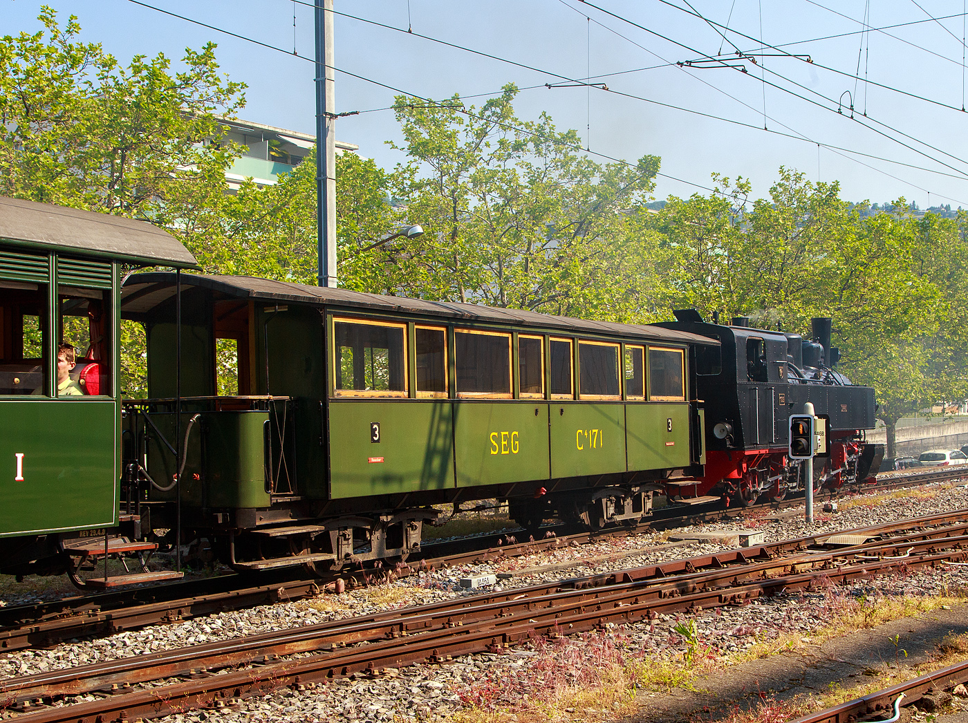 Der sehr schöne meterspurige vierachsige 3. Klasse (Raucher / Nichtraucher) Drehgestell-Großraum-Plattformwagen SEG C⁴ 171 der Museumsbahn Blonay-Chamby, ein ehemaliger Wagen Süddeutsche Eisenbahn-Gesellschaft, am 28.05.2023 im Zugverband in Vevey, dahinter die Mallet-Dampflok G 2x2/2 105  Todtnau , ex SEG 105  Todtnau .

Der Wagen wurde 1891 von der Waggonfabrik P. Herbrand & Cie. in Köln-Ehrenfeld gebaut und an die Süddeutschen Eisenbahn-Gesellschaft (SEG) geliefert, 1950 wurde der Wagen modernisiert. Am 1. Januar 1953 übernahm das Land Baden-Württemberg alle drei Betriebe und brachte sie zum 1. Oktober 1953 als Auffanggesellschaft in die Mittelbadische Eisenbahnen AG ein. Dazu gehörte u.a. die schmalspurige Zell-Todtnauer-Eisenbahn. Die Stilllegung der Zell-Todtnauer Eisenbahn für den Personenverkehr erfolgte am 25. September 1966 sowie für den Güterverkehr am 24. September 1967. Seit 1967 ist der Wagen bei der Museumsbahn BC, die Form der Beschriftung ist unhistorisch.

TECHNISCHE DATEN:
Baujahr: 1891
Hersteller: Waggonfabrik P. Herbrand & Cie. in Köln-Ehrenfeld
Spurweite: 1.000 mm (Meterspur)
Achsanzahl: 4
Länge über Puffer: 11.300 mm
Länge Wagenkasten: 10.600 mm (mit Plattformen)
Drehzapfenabstand: 6.000 mm
Achsabstand im Drehgestell: 1.200 mm
Eigengewicht: 10,0 t
Sitzplätze: 46 in der 3. Klasse