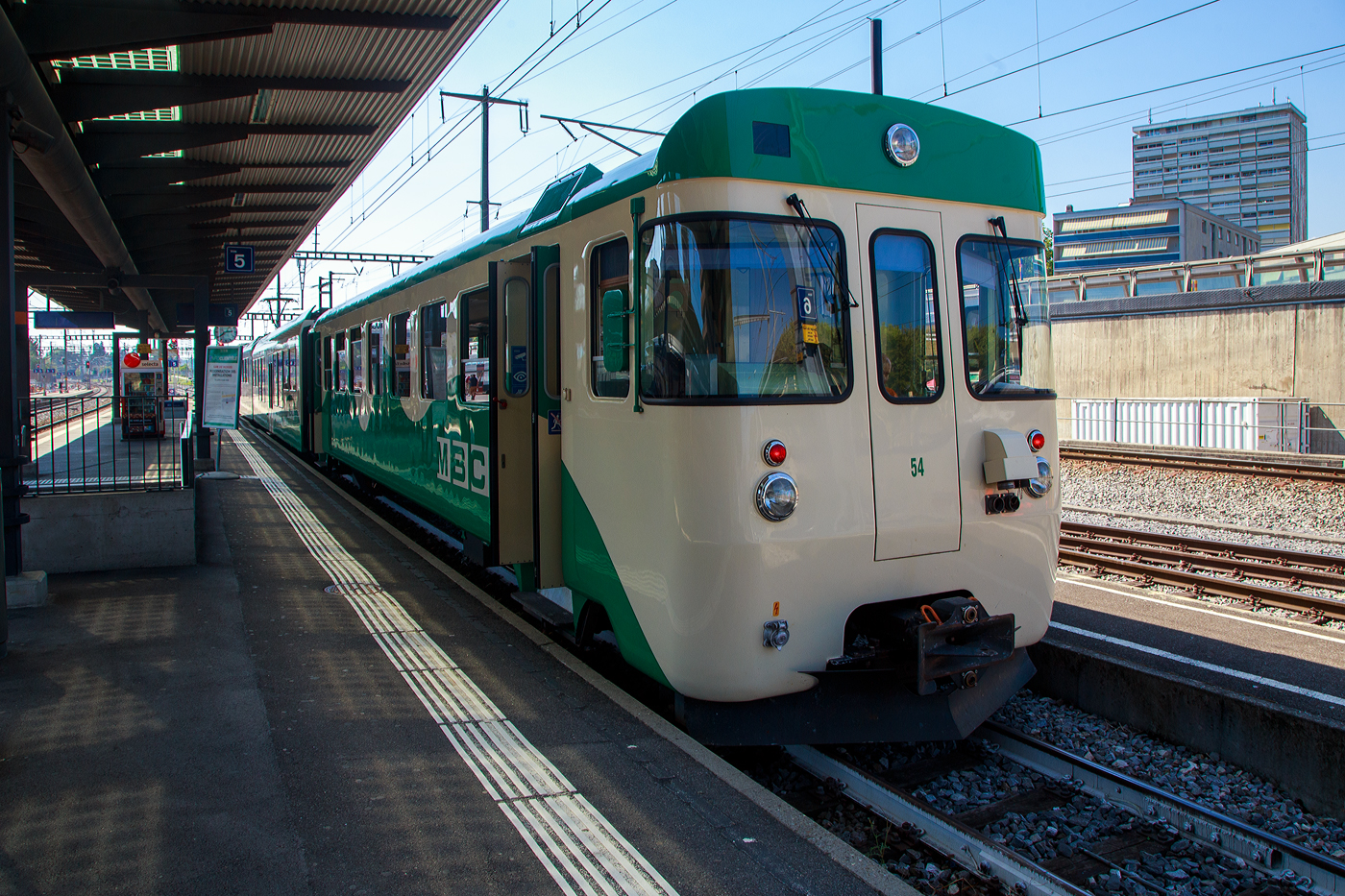Der Steuerwagen MBC/BAM Bt 54 (ex YSteC Bt 52 im November 2004 von der BAM übernommen), steht am 07 September 2023 mit einem Pendelzug (noch mit Niederflurzwischenwagen B4 2067 und dem Stadler Westschweizer Meterspur Niederflur-Triebwagen Be 4/4 31) im Bahnhof Morges zur Abfahrt als Regionalzug nach Bière bereit. 

Für die bereits 1978 bestellten je drei Triebwagen Be 4/4 der BAM und die YSteC, wurde 1980 die Bestellung um drei passende Steuerwagen (Bt 51–53) für die BAM bzw. zwei für die (Bt 51–52) für die YSteC erweitert. Diese wurden dann auch 1981 von den Ateliers de constructions mécaniques de Vevey (ACMV) gebaut, die Elektrik ist von Société Anonyme des Ateliers de Sécheron (SAAS) in Genf. Die Steuerwagen wurden 1982 ausgeliefert, sie passen aber auch zu den, wie hier modernen Stadler Westschweizer Meterspurzügen Be 4/4 .

TECHNISCHE DATEN der Steuerwagen:
Hersteller:  ACMV, SAAS
Baujahr: 1981
Spurweite: 1.000 mm (Meterspur)
Achsfolge: 2' 2' (2 Achsen in 2 Drehgestellen)
Länge über Puffer: 18.640 mm
Drehzapfenabstand: 12.830 mm
Eigengewicht: 18 t
Höchstgeschwindigkeit: 75 km/h
Sitzplätze: 56 (2. Klasse)
Kupplungstyp: +GF+ bei BAM (bei der YSteC Mittelpuffer Zp2) 
