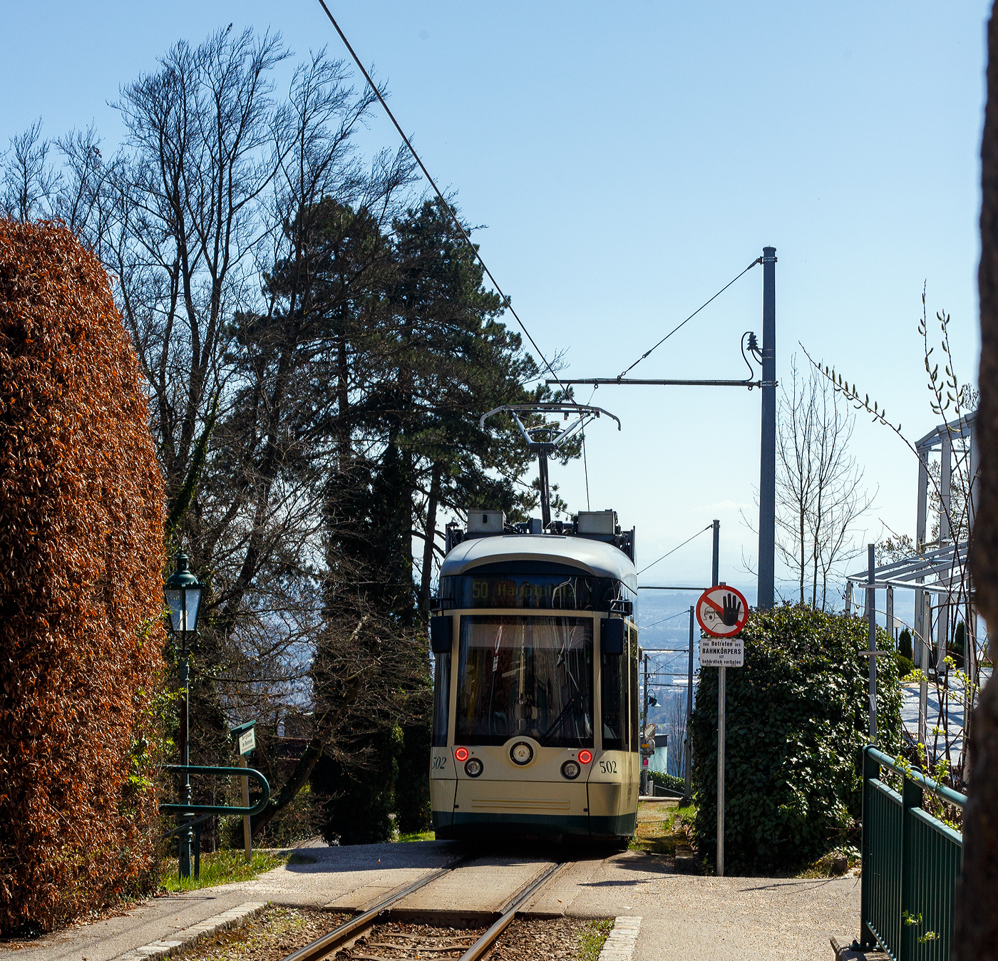 Der Triebwagen 502, ein dreiteiliger vierachsiger Zweirichtungs-Niederflur-Gelenktriebwagen vom Typ Bombardier „Mountainrunner“ verl�sst am 04 April 2025 die Bergstation P�stlingberg (519 m �.M.) und f�hrt als Linie 50 (der Linz Linien GmbH) hinab zum Hauptplatz in Linz.  

Die P�stlingbergbahn wurde von 1.000 mm auf 900 mm umgespurt und ist seit 2009 mit dem �brigen Netz der Stra�enbahn Linz verkn�pft die auch auf der Spurweite 900 mm f�hrt.  Aber f�r die Linie 50 „P�stlingbergbahn“ braucht man ein separates Ticket.  

Die P�stlingbergbahn wird, wie das gesamte Stra�enbahnnetz, von der Linz Linien GmbH betrieben und gilt, mit einer maximalen Steigung von 116 ‰, als eine der steilsten Adh�sionsbahnen der Welt. Seit 1898 beeindruckt die Linzer P�stlingbergbahn G�ste aus aller Welt mit ihrer au�ergew�hnlichen und idyllischen Streckenf�hrung.