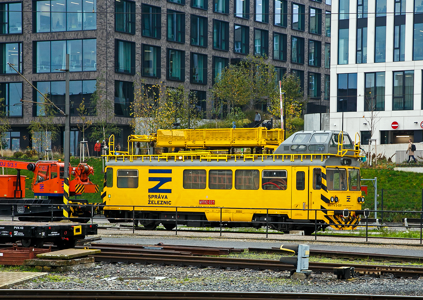 Der tschechischer Turmtriebwagen MVTV 2 – 031 (CZ-SZCZ 99 54 9439 024-9) der SŽDC - Správa železniční dopravní cesty (deutsch: Verwaltung der Eisenbahn-Verkehrswege) ist am 23.11.2022 beim Hauptbahnhof Prag (Praha hlavní nádraží) abgestellt.

Auf Basis der zweiachsigen Regionalverkehrstriebwagen der Baureihe M152.0 (später 810) wurden ab 1981, diese Bahndienstfahrzeuge für die Netzinstandhaltung, die Turmtriebwagen der Baureihe M 153.0 (ab 1988: Baureihe 892 ab 1997: MVTV 2) für die Tschechoslowakischen Staatsbahnen (ČSD) gebaut. Die Turmtriebwagen wurden als ČSD M153.0 bezeichnet, im neuen Nummernschema bekamen sie die Baureihenbezeichnung ČSD 892. Heutzutage werden sie Tschechien als Tschechien als MVTV 2 (bzw. in der Slowakei als MVTV02) bezeichnet, die UIC-Nummern ist heute 99 54 9439 xxx-x.

Geschichte:
1983 bis 1992 wurden von Vagonka Tatra in Studénka (heute Škoda Vagonka Ostrava) insgesamt 111 Wagen für Normalspur sowie drei Wagen für Russische Breitspur (1.520 mm) an die damalige ČSD (Československé státní dráhy) geliefert. Ein Fahrzeug erhielt der damaligen Spediteur DNT, aus dem sich 1992 die Firma Viamont entwickelte. Die Fahrzeuge waren als Ersatz für die auf der damaligen ČSD-Baureihe M 131.1 basierenden Reihe 890 bestimmt. 1981 entstand bei Studenka ein Prototyp, nach ausgiebigen Tests wurden die Serienfahrzeuge geliefert. Sie konnten im mit 3 kV Gleichspannung elektrifizierten Netz für Arbeiten unter Spannung, auf mit 25 kV Wechselspannung bei 50 Hz elektrifizierten Strecken jedoch nur bei abgeschalteter Fahrleitung verwendet werden.

Die regelspurig gebauten Triebwagen wurden als M 153.0, die breitspurigen als M 153.5 eingeordnet. 1988 wurden daraus mit der Einführung der EDV-Nummern die Reihen 892 bzw. 892.8. Ab 1997 wurden die Triebwagen als Arbeitsfahrzeuge deklariert, und die Fahrzeuge in Tschechien erhielten die Bezeichnung MVTV 2, in der Slowakei wurden für die Normalspur die Fahrzeuge als MVTV 02 und für die Breitspur die Fahrzeuge als MVTV 03 bezeichnet. Die Fahrzeuge dienen zur Kontrolle der Fahrleitungslage und auch deren Unterhaltung, außerdem werden mit ihnen technologische Transporte von Mitarbeitern und Überführungsfahrten durchgeführt. 

Im Jahr 2007 erhielten alle Fahrzeuge eine neue Antriebsanlage auf Grundlage der ČD-Baureihe 814. Der Umbau wurde von der Firma Pars Nova in Šumperk durchgeführt. Da gleichzeitig die elektrischen Einrichtungen auf den neuesten Stand gebracht wurden, sind die Arbeiten als komplette Modernisierungsmaßnahme ausgeführt worden. Der Umbau beinhaltete die Ausrüstung mit einem neuen Dieselmotor TEDOM TD242RHTA25 und einem neuen Differentialwandlergetriebes VOITH DIWA 864.3E. Dank dieser Umbaumaßnahme erhöhte sich die Anzahl der Getriebestufen von 2 auf 4 und die zugelassene Höchstgeschwindigkeit stieg auf 90 km/h. Außerdem wurde die Bordspannung von 48 V auf 24 V verringert. Die umgebauten Fahrzeuge werden als MVTV 2.1 bezeichnet und sie sollen nach dem Umbau noch mindestens 20 Jahre weiter genutzt werden können.

Konstruktion
Die Wagen sind von der ČSD-Baureihe M 152.0 abgeleitet. Im Wagen gibt es einen Arbeits- und einen Lagerraum sowie sanitäre Einrichtungen. Auf dem Dach befinden sich die Inspektionskanzel sowie eine gegenüber den Wagenkasten isolierte Arbeitsbühne für Arbeiten an der Fahrleitung, z. B. Auswechseln von Isolatoren oder Stützpunktteilen. Vorhanden ist ein Einholmstromabnehmer als Messstromabnehmer. Neben der Arbeitsbühne befinden sich Laufstege, die bis zu den Stirnseiten reichen. An den Stirnseiten der Fahrzeuge gibt es zusätzlich kurze Laufstege für den Übergang auf Dacharbeitsplattformen gekuppelter Fahrzeuge.

Die mit den Triebwagen der Reihe 810 identische Antriebsanlage ermöglichte eine kleinste Dauergeschwindigkeit von 5 km/h. Bei den modernisierten MVTV 2.1 (neue Antriebsanlage wie ČD 814) ist die Arbeitsfahrt von 0 bis 5 km/h regelbar.

TECHNISCHE DATEN:
Hersteller: Vagonka Tatra in Studénka (heute Škoda Vagonka Ostrava)
Baujahre 1981 bis 1992 (
Hergestellte Stück:  112 (Normalspur) und 3 (Breitspur)
Spurweite: 1.435 mm (Normalspur)
Achsformel:  1'A' 
Länge über Puffer:  13.970 mm
Höhe: 4.635 mm
Breite: 3.703 mm
Achsabstand: 8.000 mm
Dienstgewicht: 26 t
Höchstgeschwindigkeit: 80 km/h (MVTV 2.1 - 90 km/h)
Motor:  LIAZ ML 634, ein 6-Zylinder-Reihendieselmotor mit Direkteinspritzung mit 600 bis 2.150 U/min (MVTV 2.1 - TEDOM TD242RHTA26)
Installierte Leistung:  155 kW (MVTV 2.1 - 265 kW)
Anfahrzugkraft: 29 kN
Kraftübertragung: hydromechanisch (Dieselmotor auf Hydrogetriebe über Gelenkwelle auf das Achsgetriebe)
Hydrogetriebe: Praga 2M70 (MVTV 2.1 - VOITH Diwa 884.5)
Achsgetriebe: NKR 16
Tankinhalt: 300 l

Die SŽDC - Správa železniční dopravní cesty (deutsch: Verwaltung der Eisenbahn-Verkehrswege) ist das staatliche Eisenbahninfrastrukturunternehmen in Tschechien (ähnlich wie in Deutschland die DB Netz AG), die NVR Bezeichnung ist SZCZ. Die SŽDC ist als staatliche Organisation  der Betreiber und Eigentümer aller Eisenbahnstrecken in tschechischem Staatsbesitz. Die Gesellschaft entstand am 1. Januar 2003 durch Abspaltung von der staatlichen Eisenbahngesellschaft České dráhy (ČD).
