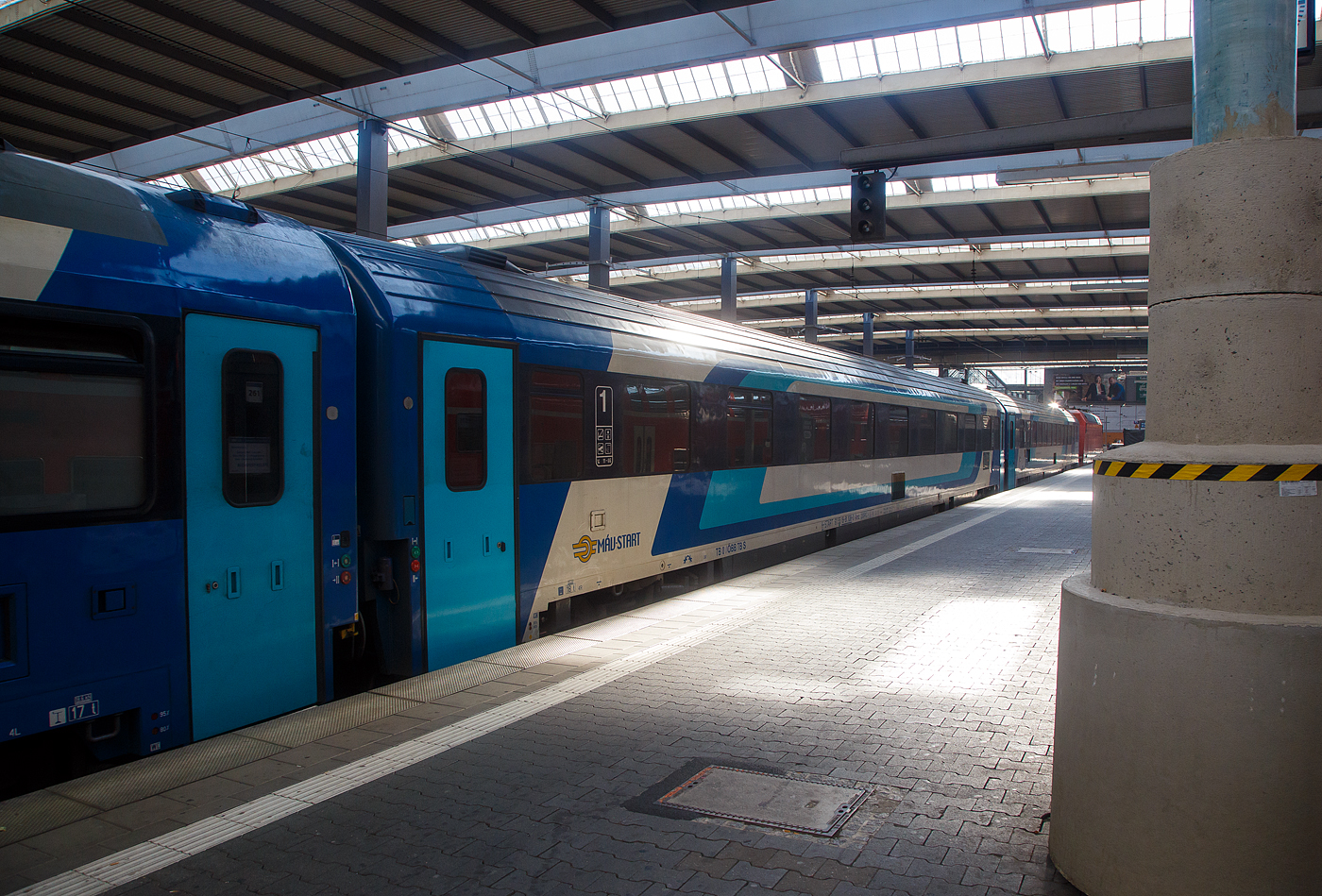 Der ungarische 1te Klasse Reisezugwagen (Abteilwagen) H-START 61 55 19-91 108-0 der Gattung Amz der M�V-START Zrt. (Ungarische Staatsbahnen, Personenverkehrssparte) am 25 Juli 2022 im Hbf M�nchen eingereiht im Zugverband des EN 462 „K�lm�n Imre“ (Budapest - Győr - Hegyeshalom – Wien - Linz – Salzburg - M�nchen) / EN 498 „Lisinski“ (Zargreb – Dobova – Ljubjana – Jesenice – Villach – Salzburg – M�nchen).

TECHNISCHE DATEN:
L�nge: 26.400 mm
Drehzapfenabstand: 19.000 mm
Baujahr: 1994
Hersteller: CAF
Eigengewicht: 50 t
Sitzpl�tze: 54 in 9 Abteilen � 6 Sitze in der 1. Klasse
WC/Toiletten: 2
H�chstgeschwindigkeit: 200 km/h
Bremse: KE-PR-Mg

Die Ungarischen Staatsbahnen (MAV) haben zu Beginn der 1990er Jahre eine ganze Wagenfamilie f�r den Internationalen Schnellzugsverkehr beschafft. Die Beschaffung von 76 Fahrzeugen in acht verschiedenen Fahrzeugtypen erfolgte beim spanischen Hersteller CAF. Die CAF-Schnellwagen sind f�r eine H�chstgeschwindigkeit von 200 km/h ausgelegt, druckerdicht und verf�gen �ber eine Klimaanlage und ein Vakuum-WC. Die CAF-Wagen verteilen sich auf die Fahrzeuggattungen 1. Klasse Gro�raumwagen Ampz 10-91 (8 Wagen, Baujahr 1994), die 1. Klasse Abteilwagen Amz 19-91 (9 Wagen, Baujahr 1994), die 2. Klasse Gro�raumwagen Bmpz 20-91 (18 Wagen, Baujahr 1994), die 2. Klasse Abteilwagen Bmz 21-91 (12 Wagen, Baujahr 1993), die 2. Klasse Liegewagen Bcmz 50-91 (9 Wagen, Baujahr 1994), den 1./2. Klasse Schlafwagen WLABmz 71-91 (6 Wagen, Baujahr 1994), den Speisewagen WRmz 88-91 (9 Wagen, Baujahr 1994) und den Gep�ckwagen Dms 85-91 (5 Wagen, Baujahr 1995).
