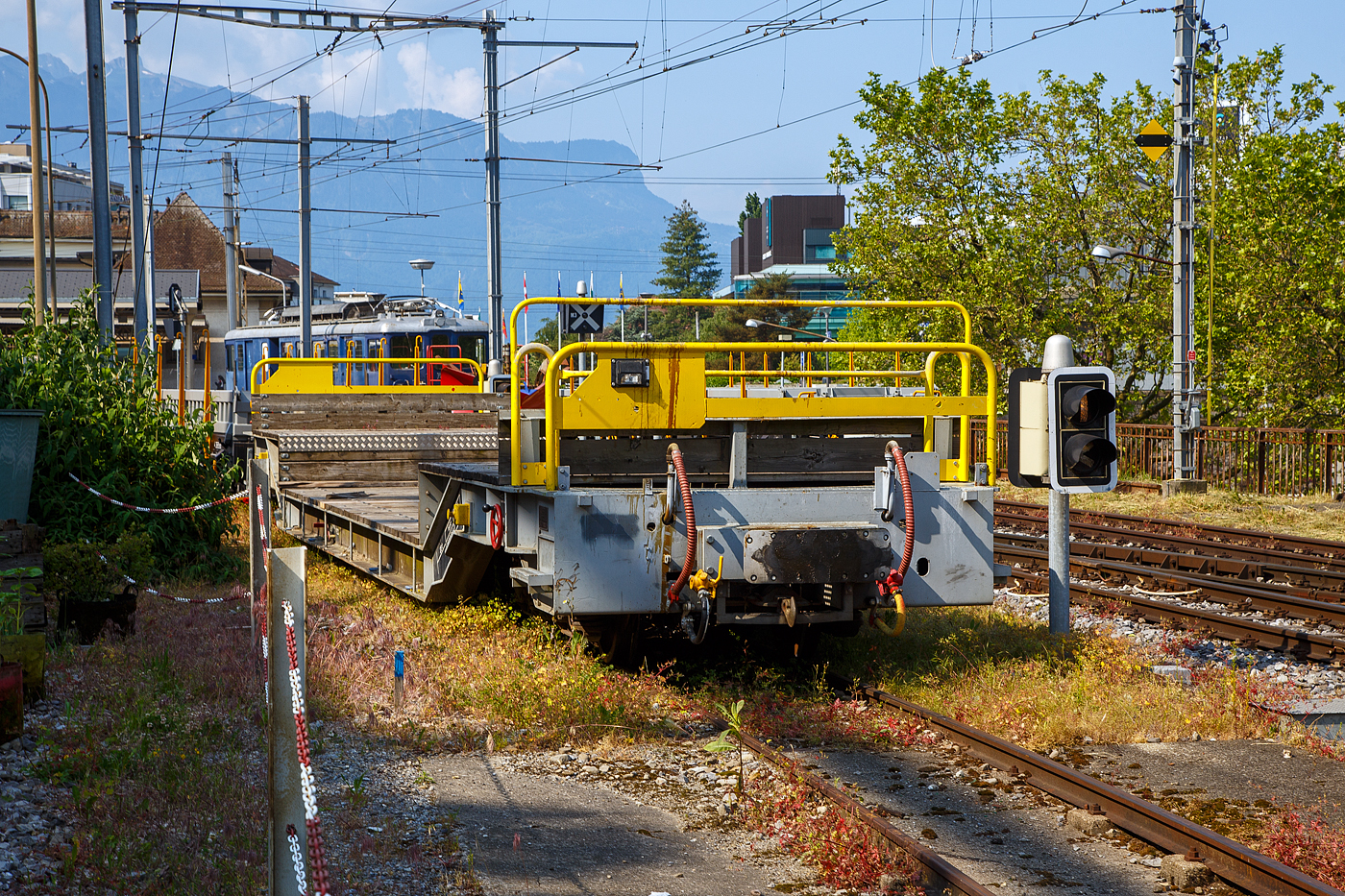 Der vierachsige Drehgestell-Tiefbett-Flachwagen als Dienstgüterwagen MOB X 775 der Montreux-Berner Oberland-Bahn, ex RhB Sbk-v 7705, abgestellt am 28.05.2023 in Vevey.

Der Wagen wurde 1999 von der Josef Meyer Waggon AG in Rheinfelden (CH) unter der Fabriknummer 2314 gebaut und an die RhB (Rhätische Bahn AG - Bündner Güterbahn) als Niederflur-Containerwagen Sbk-v 7705 (RhB Serie Sbk-v 7701-7715) geliefert. Im Februar 2013 wurde der Wagen bei der RhB ausrangiert und an die MOB verkauft. Bei der MOB wurde der Wagen umgebaut und an die MOB Normalien angepasst. Zum Umbau gehörte die komplette Belegung des Stahlrahmens mit Holzbohlen, so wurde aus dem Containerwagen ein Tiefbettflachwagen, das Eigengewicht stieg von 14,2 t auf nun 15,6 t. Im Juni 2013 erfolgte die Inbetriebnahme als X 775 bei der MOB.

1999 bzw. 2002 stellt die RhB vierachsige Drehgestelltragwagen Sbk-v 7701-7715 (26 t Traglast) und Sb-v 7716-7730 (verstärkt, mit 30 t Traglast) in Dienst. Bedingt durch den Niederfluranteil kann zwar nur ein Container transportiert werden, dies allerdings auch auf dem eingeschränkten Lichtraumprofil der Berninabahn.

Sechs dieser Wagen Niederflur-Containerwagen der  RhB Serie Sbk-v 7701-7715 (Sbk-v 7701 bis 7706) wurden von der MOB gekauft und zu den Tiefbett-Flachwagen MOB X 771 bis 776 umgebaut.

TECHNISCHE DATEN:
Hersteller: Josef Meyer Waggon AG in Rheinfelden (CH)
Baujahr: 1999 (Umbau 2013 durch MOB)
Spurweite: 1.000 mm (Meterspur)
Achsanzahl: 4 (in 2 Drehgestellen)
Länge über Puffer: 16.300 mm 
Breite: 2.660 mm
Drehzapfenabstand: 10.370 mm 
Achsabstand im Drehgestellt: 1.400 mm
Laufraddurchmesser: 750 mm
Drehgestell- Typ (Bauart): JMR Or 92/12
Ladelänge im Tiefbett: ca. 7.800 mm
Höhe Tiefbett  ab Schienenoberkante: ca. 600 mm
Eigengewicht: 15.600 kg (ursprünglich bei RhB 14.200 kg)
Max. Ladegewicht: 23 t
Höchstgeschwindigkeit: 90 km/h (>7 t Beladung) / 80 km/h (ab 7 t Beladung)
Feststellbremse: Ja
Kupplungen: Mittelpuffer mit einer Schraubenkupplungen (Zp 1)

Quellen: x-rail.ch, RhB - Bündner Güterbahn und eigene Sichtung