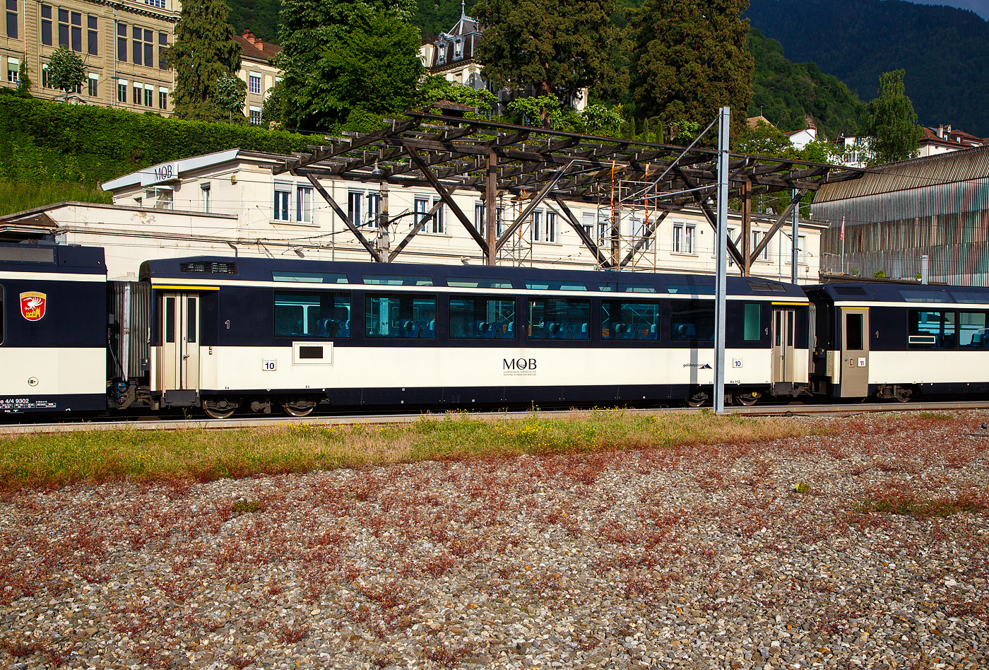 Der vierachsige MOB 1. Klasse Panoramawagen As 112 „goldenpass“  ( Panoramic Express -Wagen) ist am 26. Mai 2023 beim Bahnhof Montreux abgestellt.

TECHNISCHE DATEN:
Hersteller: Ramseier + Jenzer AG Bern (R+J), MOB, SIG
Baujahr: 1982, 2001 Umbau mit Verl�ngerung um 1.775 mm
Spurweite: 1.000 mm (Meterspur)
Achsanzahl: 4 (in 2 Drehgestellen)
L�nge �ber Puffer: 18.600 mm 
Wagenkastenl�nge: 17.760 mm
Drehzapfenabstand: 12.830 mm (urspr. 11.055 mm)
Achsabstand im Drehgestell: 1.800 mm
Drehgestell Typ: SIG-Torsionsstab
Laufraddurchmesser: 750 mm (neu)
Eigengewicht: 22,6 t
Dienstgewicht: 26,2 t
H�chstgeschwindigkeit: 100 km/h
Sitzpl�tze: 33 in der 1. Klasse, Sitzanordnung 2 + 1, vis � vis
Sitzpl�tze urspr�nglich vor der Verl�ngerung: 36 in der 1. Klasse (2+2)
WC: 1 (Geschlossenes WC-System / Vakuumtoilette)
Kupplung: Automatischen SCHWAB Kupplung