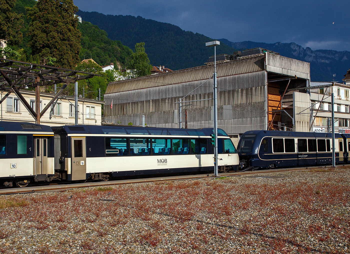 Der vierachsige MOB 1.Klasse Panorama-Steuerwagen Ast 152 „goldenpass“  (ex Arst 152  Panoramic Express -Wagen) ist am 26. Mai 2023 beim Bahnhof Montreux abgestellt.

Die MOB beschaffte 1993 zwei Panoramawagen als Steuerwagen Arst 151–152 mit erh�htem F�hrerstand und 8 Aussichtspl�tzen hinter der Frontscheibe, diese Passagiere k�nnen so den Blick nach vorne auf die Strecke (bei entspr. Fahrtrichtung) genie�en. Die beiden Wagen Ast 151 und 152 und die beiden As 153 und 154, wurden mit einer GDe 4/4 in der Mitte, als reiner 1. Klasse-Zug Crystal Panoramic anstelle des Superpanoramic am Wochenende und im Sommer t�glich eingesetzt.

Der �brige Passagierraum war urspr�nglich ist als Barwagen mit L�ngssitzb�nken ausgestattet. Auf Tische wurde verzichtet und die Sitze am Wagenende in Reihenbestuhlung angeordnet.

TECHNISCHE DATEN:
Hersteller: Breda, Baujahr 1993, sowie MOB und SIG (Drehgestelle)
Spurweite: 1.000 mm (Meterspur)
Achsanzahl: 4 (in 2 Drehgestellen)
L�nge �ber Puffer: 18.700 mm
Wagenkastenl�nge: 18.060 mm
Drehzapfenabstand: 12.830 mm
Achsabstand im Drehgestell: 1.800 mm
Drehgestell Typ: SIG-90
Laufraddurchmesser: 750 mm (neu)
Eigengewicht: 20,7 t
H�chstgeschwindigkeit: 120 km/h
Sitzpl�tze: 28 (in der 1. Klasse) und 8 (VIP)
WC: 1
Kupplung: Automatischen SCHWAB Kupplung