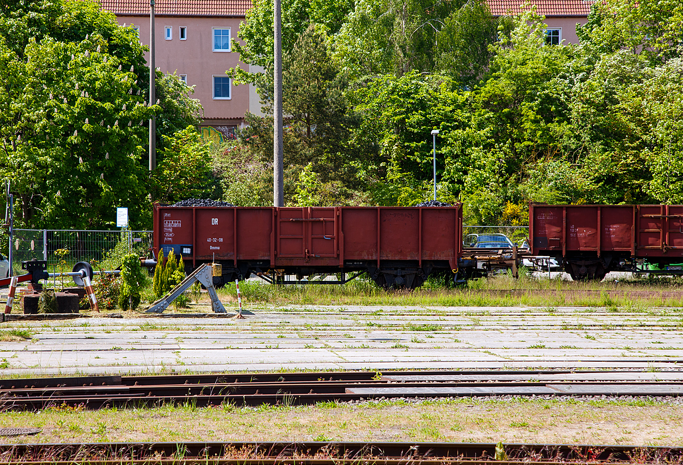 Der zweiachsige offene G�terwagen (Kohlewagen) ex DR 40 – 32 – 08 der Gattung/Bauart Ommu 40.0 (heutige Gattung „Es“) der Mecklenburgische Eisenbahnfreunde Schwerin e.V. am 16 Mai 2022 beim MEF - Mecklenburgisches Eisenbahn- und Technikmuseum (Schwerin), dem einstigen Bahnbetriebswerk am Hauptbahnhof.

Diese Wagen eignet sich f�r Transport von Kohle, Koks, Holz, Schrott, Stahl und Schotter. Diese Wagen zeichnen sich durch einen flachen Boden und feste Seitenw�nde (Borde) aus. Der Wagen hat an den L�ngsseiten jeweils mittig eine Fl�gelt�re (lichte Weite von je 1.800 x 1.800 mm), sowie an beiden Stirnseiten jeweils eine Stirnklappe. Der Wagen ist, mittels Waggonkippanlage bzw. Drehkipper, seiten- und stirnkippbar. 

Ab 1964 begann das RAW Dresden mit dem Bau von solcher neuen offenen G�terwagen nach UIC Standard. Die Waggons werden bei der Deutsche Reichsbahn (DR) eingereiht als Ommu 40.0 (Offene G�terwagen
f�r mehr als 20 t Lademasse). Es wurden mehr als 20.000 Exemplare gebaut.

TECHNISCHE DATEN:
Spurweite: 1.435 mm (Normalspur)
Achsanzahl: 2
Gattung: Ommu
L�nge �ber Puffer: 10.000 mm
Achsabstand: 5.400 mm
Ladel�nge: 8.760 mm
Ladefl�che:  24,1 m�
Eigengewicht: 11.500 kg
Max. Zuladung: 28,5 t (ab Streckenklasse C)
H�chstgeschwindigkeit: 90 km/h
Bremse: KE-GP
