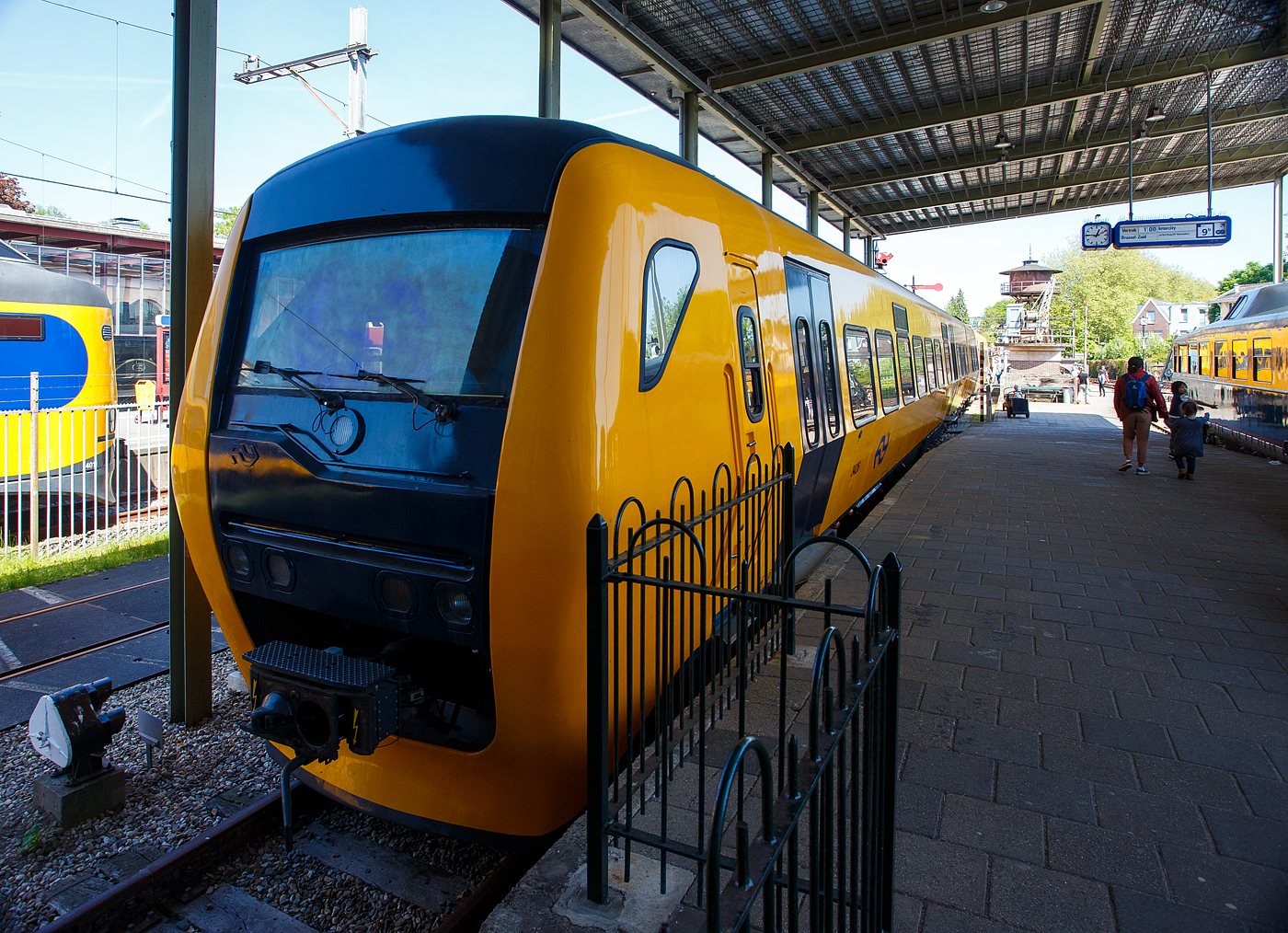 Der zweiteilige Dieseltriebwagen NS 3426 „Buffel“, deutsch Büffel, NL-NS 95 84 5131426-6, (Bk 3426 + ABk 3426), der NS Baureihe/Serie DM '90 (Dieselmaterieel '90), am 29 April 2025 im Het Spoorwegmuseum (bis 2005 NSM - Nederlands Spoorwegmuseum / Niederländischen Eisenbahnmuseum) in Utrecht im Bahnhof Maliebaanstation. Ein sehr schönes Eisenbahnmuseum das zum Verweilen einlädt, leider fehlte uns dieses Mal die Zeit dafür. 

Der diesel-hydraulische Triebzug wurde 1998 von der Waggonfabrik Talbot GmbH & Co. (heute Bombardier) in Aachen (D) für die NS - Nederlandse Spoorwegen N.V. (Niederländische Eisenbahnen AG) gebaut und geliefert. Die komplette elektrische Ausrüstung, sowie die Zugsteuerungs- und Diagnosefunktionen, durch Holec in Ridderkerk (NL), heute Alstom. Die Innenausstattung wurde von DUEWAG (Düsseldorfer Waggonfabrik) in Krefeld (D), heute Siemens, gefertigt und von dort aus wurden die Züge auch in die Niederlande transportiert. Der Büffel bzw. Triebzug 3426 ging 2017 außer Betrieb und wurde Anfang 2018 an das Eisenbahnmuseum übergeben.

Dieselmaterieel '90 (DM '90):
Die zweiteiligen Dieseltriebwagen der NS-Serie Dieselmaterieel '90 (DM '90), offiziell Buffel (Büffel) genannt, da die Frontform an einen Büffelkopf erinnert, war eine Serie aus 53 zweiteiligen Dieseltriebwagen die von Waggonfabrik Talbot in Aachen gebaut wurden. Die Triebzüge basieren teilweise auf dem Stoptrein-Material '90, dem „Railhopper“. Die Buffels wurden ab 1996 von der Niederländischen Eisenbahn und ab 1999 von Syntus eingesetzt. Die letzten Züge der Niederländischen Eisenbahn waren bis 2017 im Einsatz.

Die Büffel waren auf nichtelektrisierten Regionalbahnstrecken der NS in den Niederlanden im Einsatz. Heute verkehren auf diesen Bahnstrecken andere private Eisenbahngesellschaften (wie u.a. Syntus, Arriva und Connexxion) und nicht die NS. So braucht die NS keine Dieselzüge mehr und verabschiedete sich vom Büffel.

Ausstattung und Technik:
Wie der elektrische Triebzug Stoptreinmaterieel '90 (auch von Talbot gebaut), der die Grundlage für den Büffel bildete, weist der DM'90 eine etwas andere gestaltete maximale Breite von 3,20 Metern auf. Durch seine geschickte Gestaltung der Wagenkästen mit gekrümmten Seitenwänden) und die Begrenzung des seitlichen Federwegs ist es möglich, das Wagenprofil 30 Zentimeter breiter als bei den meisten Zügen zu machen und dabei immer noch das Standardprofil einzuhalten. Durch diese Breit wäre es möglich gewesen, in der zweiten Klasse fünf Sitzplätze nebeneinander zu schaffen, was jedoch nicht umgesetzt wurde. Angetrieben wird DM'90 von zwei 6-Zylinder-Reihen-Dieselmotoren von Cummins (Typ NTA 855 R4) mit einer maximalen Leistung von jeweils 320 kW. Das Getriebe von Voith (Typ T211 rzze) ist hydrodynamisch (Voith, Typ T211 rzze). Der DM'90 hat eine Höchstgeschwindigkeit von 140 km/h. Der Büffel konnte in Mehrfachtraktion mit der älteren (ebenfalls dieselhydraulischen) Wadloper (DH1 und DH2) fahren, allerdings war die Höchstgeschwindigkeit dann auf die des Wadlopers von 100 km/h begrenzt. Der Büffel bot 135 Passagieren Sitzplätze (123 in der zweiten Klasse und 12 in ersten Klasse). Als Drehgestelle dienten die Typen RMO 9000 (von Stork RMO Werkspoor), die auch für die doppelstöckigen Interregio-Züge verwendet wurden. Ursprünglich sollten die DM‘90 den gleichen Kopf wie SM‘90 haben, auf Anraten der Marketing- und Designabteilung wurde jedoch der stromlinienförmige Kopf verwendet, der eigentlich schon für SM‘90 entwickelt worden war und Reisende stärker ansprechen sollte.

Die Kombination aus Scheibenbremsen und der ruhige Lauf führte zu einer schlechten Erkennung der Ausrüstung. Auf den Strecken, auf denen die DM'90 verkehrte, installierte der Bahnbetreiber häufig Achszähler. 

TECHNISCHE DATEN:
Serie: NS 3400 - DM '90 (Dieselmaterieel '90) „Buffel“
Gebaute Anzahl: 53
Nummerierung: 3401-3453
Typ: diesel-hydraulischer Triebzug
Baujahre: 1996 bis 1998
Ausmusterung: 2017
Hersteller: Waggonfabrik Talbot GmbH & Co. in Aachen (D), heute Bombardier
Zulieferung elektrische Ausrüstung: Holec in Ridderkerk (NL), heute Alstom
Zulieferung Innenausstattung: DUEWAG in Krefeld (D), heute Siemens
Spurweite: 1.435 mm (Normalspur)
Achsfolge: 2'B' + B'2' (8 Achsen in 4 Drehgestellen)
Zusammensetzung: Bk + ABk

Länge über Kupplung: 52.340 mm
Breite: 3.200 mm
Höhe: 4.142 mm
Treib- und Laufraddurchmesser: 920 mm (neu) / 840 mm (abgenutzt)
Achsabstand im Triebdrehgestell: 2.750 mm
Achsabstand im Laufraddrehgestell: 2.600 mm
Motoren: 2 Stück Cummins 6-Zylinder-Reihen-Dieselmotoren vom Typ NTA 855 R4
Motorleistung: 2 x 340 KW = 640 kW (870 PS)
Getriebe: 2 Stück hydrodynamisches Turbogetriebe von Voith vom Typ T211 rzze
Höchstgeschwindigkeit: 140 km/h
Beschleunigung: 0,6 m/s²
Bremsverzögerung: 1,2 m/s² 
Eigengewicht: 95,2 t 
Fußbodenhöhe: 1.160 mm 
Anzahl der Doppeltüren je Seite: 4 [zweiteilige Pneumatische Pendeltüren 1.300 mm breit]
Sitzplätze (gesamt): 135
Sitzplätze in der 1. Klasse: 12
Sitzplätze in der 2. Klasse: 123
Anzahl der Klappsitze: 34
Stehplätze (4 Pers./m²): 156
Tankvolumen: 2 x 1.000 = 2.000 Liter
Kupplung: Scharfenberg

Verkäufe:
32 Triebzüge wurden 2020 an die SKPL - Stowarzyszenie Kolejowych Przewozów Lokalnych (Vereinigung von Lokalbahnbetrieben) nach Polen verkauft, wo sie nach Modifizierungen seit 2024 als SD85 im Einsatz sind. 

14 Triebzüge wurden 2021 an die Firma Brouwer in Blerick (bei Venlo) verkauft, die diese konnte sie an die rumänische Betreiber Ferotrans-TFI verkaufen.

1 Triebzug (3452) wurde im Januar 2021 an die HTFSE Happy Train Fleet Services B.V. verkauft. Dieser Zug soll zukünftig wieder fahrbereit gemacht werden.

Von den 53 Zuggarnituren wurden letztlich 47 verkauft. 
5 Triebzüge (3403, 3405, 3409, 3410 und 3424) wurden aus unterschiedlichen Gründen verschrottet. 
Der Triebzug 3426 wurde an das Eisenbahnmuseum übergeben.
