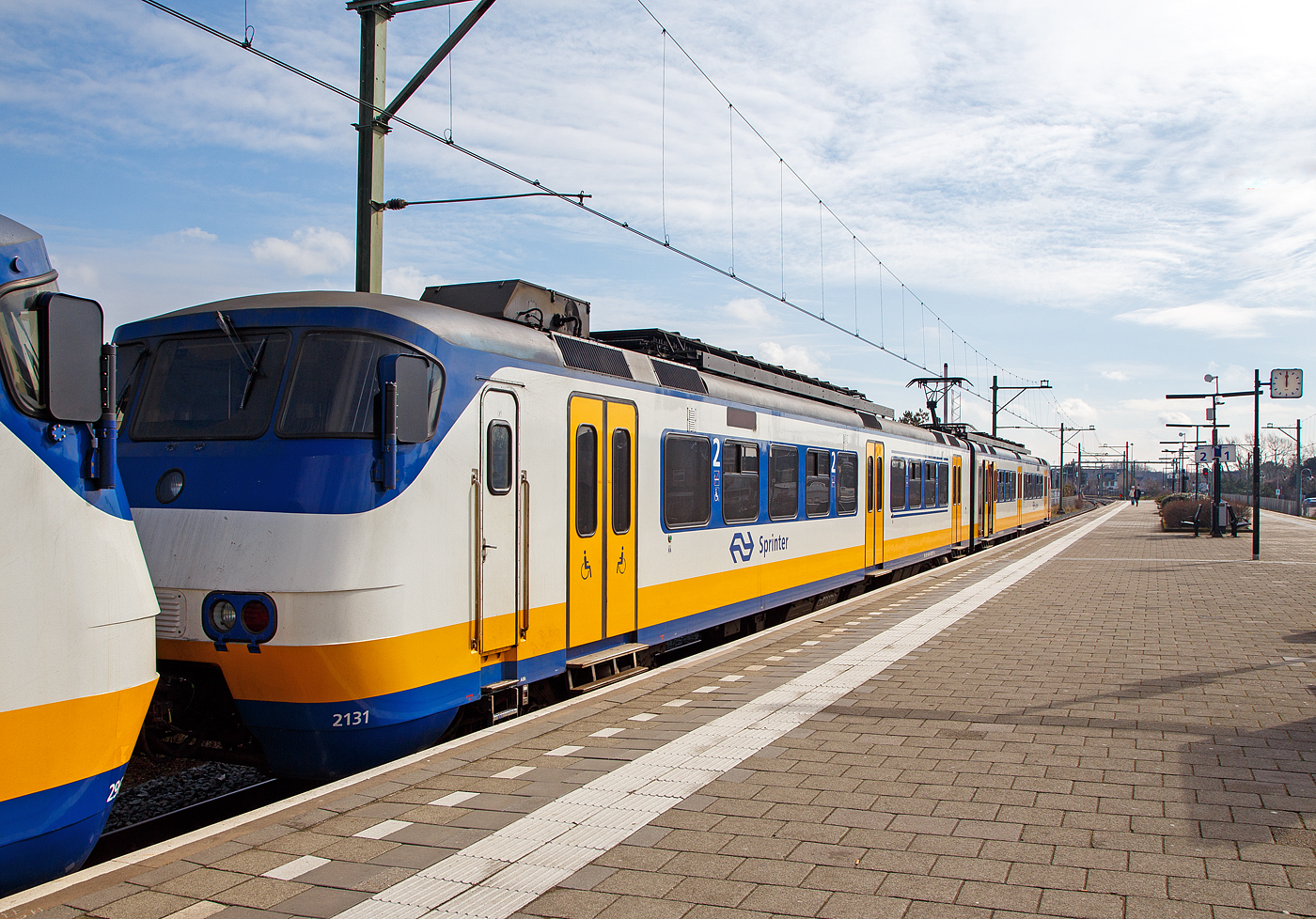 Der zweiteilige NS Sprinter SGMm 2131 (auch Plan Y oder Mat ’74 bekannt), gekuppelt mit dem dreiteiligen SGMm 2967 stehen am 31 M�rz 2018 im Bahnhof Zandvoort aan Zee f�r die Abfahrt nach Amsterdam Centraal bereit.

Die Stadsgewestelijk Materieel (SGM) oder Sprinter (auch Plan Y und Mat ’74) waren elektrische Triebz�ge f�r den Nahverkehr in den Niederlanden. Zwischen 1975 und 1980 baute die Waggonfabrik Talbot in Aachen 75 zweiteilige Z�ge f�r die Nederlandse Spoorwegen (NS). 1983 wurden 45 Z�ge mit einem Mittelwagen verl�ngert und 15 dreiteilige ET neu gebaut. Von 2003 bis 2009 wurden die Sprinter von Bombardier modernisiert und erhielten die Bezeichnung SGMm.

Vorserie:
Um 1970 planten die NS eine st�rkere Trennung der Zugkategorien Stoptrein und Intercity. F�r die kurzen Haltabst�nde des Stoptrein waren die Mat ’64 nicht mehr ausreichend. Stattdessen wurden neue Elektrotriebz�ge mit vielen T�ren und guter Beschleunigung ben�tigt. Daher erhielt Talbot 1972 den Auftrag, 15 Zweiwagenz�ge eines derartigen Typs zu liefern. Zulieferer waren die SIG f�r die Drehgestelle und Holec f�r die elektrische Ausr�stung.

Alle Achsen der Triebz�ge wurden mit 160 kW leistenden Motoren angetrieben, sodass die Z�ge in 72 Sekunden auf ihre H�chstgeschwindigkeit von 120 km/h beschleunigen konnten. Es gab keinen �bergang zwischen den beiden Wagen und keine Toiletten.

Serie: 
Zwischen 1978 und 1980 wurde eine Serie von 60 zweiteiligen Elektrotriebz�ge geliefert. Diese Z�ge erhielten einen Durchgang zwischen beiden Teilen und eine Toilette. 

1983 wurden 45 antriebslose Mittelwagen gefertigt und in 45 ET der neuen Serie. Die Mittelwagen hatten nur zwei T�ren pro Seite statt drei wie die Endwagen. Im gleichen Jahr wurden noch 15 dreiteilige Elektrotriebz�ge in der gleichen Ausf�hrung gebaut und geliefert.

Nach �ber zwanzig Jahren Betrieb begann im Sommer 2003 ein Modernisierungsprogramm f�r die Fahrzeuge. Bis 2009 wurden alle Z�ge grundlegend �berholt. Alle Mittelwagen erhielten eine zus�tzliche T�r in der Wagenmitte und die Zweiwagenz�ge der Probeserie wurden durchg�ngig begehbar umgebaut. Der Innenraum wurde �berarbeitet und erhielt eine Klimatisierung und ein Fahrgastinformationssystem. Die Z�ge erhielten die blau-wei�e Lackierung, die seitdem alle Sprinter-Z�ge erhalten.

Mit der Inbetriebnahme der SNG in gro�er Zahl wurden die SGM von 2018 bis 2021 vollst�ndig ausgemustert. Der Zweiwagenzug 2133 blieb im Eisenbahnmuseum in Utrecht erhalten. Die �brigen Fahrzeuge wurden im Technik Centrum Eindhoven ausgeschlachtet.

TECHNISCHE DATEN
Nummerierung (nach Umbau): 21xx (Zweiteiler), 29xx (Dreiteiler)
Anzahl: 90
Hersteller: 	Talbot, SIG, Holec
Baujahre: 	1975–1983
Ausmusterung: 2018–2021
Spurweite: 	1.435 mm (Normalspur)
Achsformel: Bo‘Bo‘+Bo‘Bo‘ bzw.  Bo‘Bo‘(+2‘2‘)+Bo‘Bo‘
L�nge �ber Kupplung: 52 292 mm bzw. 78 692 mm
Breite: 2 800 mm
Leergewicht: 106 t bzw. 142 t
H�chstgeschwindigkeit: 120 km/h
Dauerleistung: 1.280 kW (8�160 kW)
Treibraddurchmesser: 	950 mm
Stromsystem: 1,5 kV = (Gleichstrom)
Kupplungstyp: Scharfenberg
Sitzpl�tze (nach Umbau) in der 1. Klasse: 24 bzw.  36
Sitzpl�tze (nach Umbau) in der 2. Klasse: 80 bzw. 128
Klappsitze: 38 bzw. 58 
