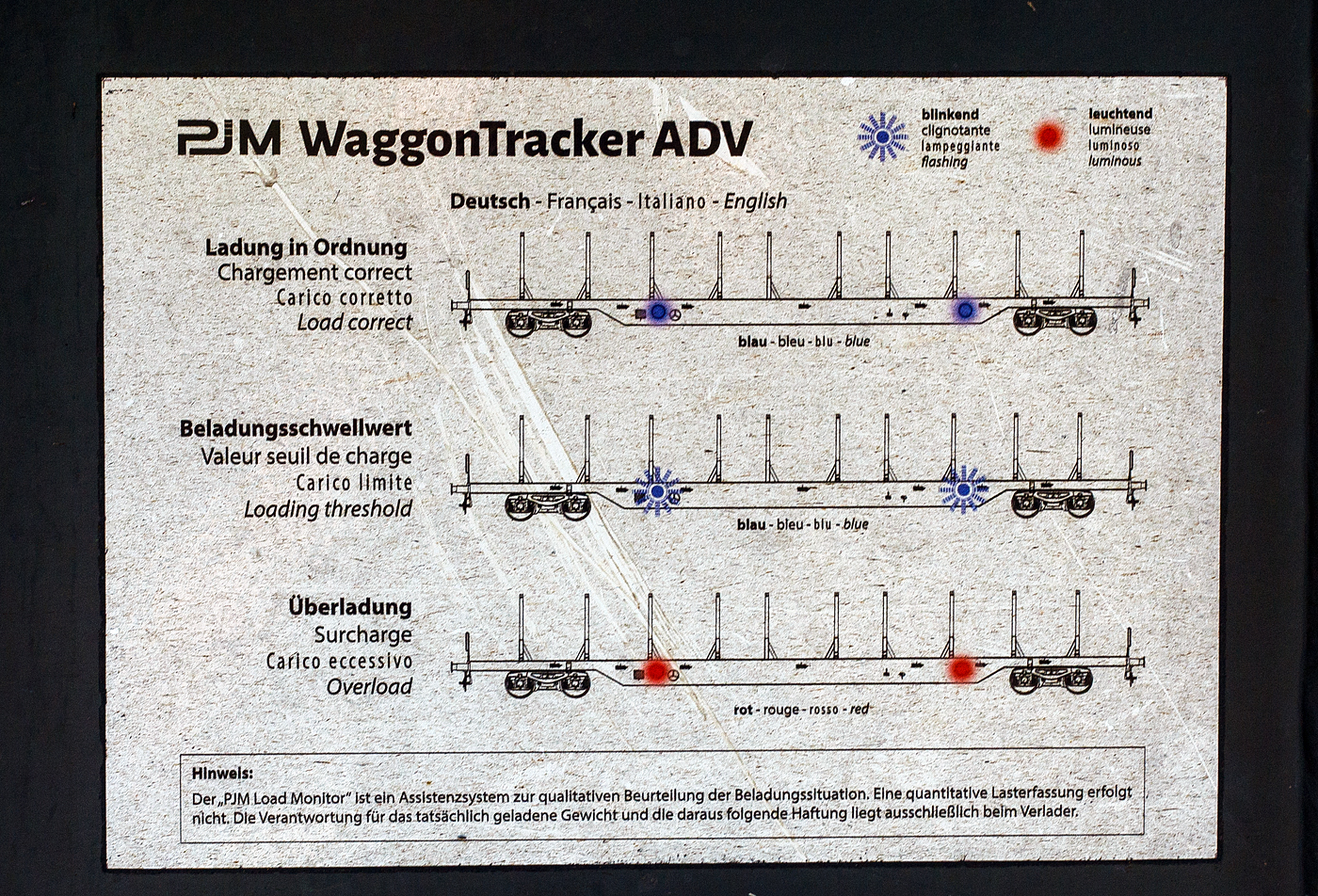 Detailbild der Beladeanzeige/Funktionsbeschreibung zur Benutzung vom PJM WaggonTracker ADV angebracht auf der Wagenlängsseite des vierachsigen Drehgestell-Flachwagen (Holzwaggon), 81 80 4723 525-9 D-TWA, der Gattung Snps, der TRANSWAGGON GmbH (Hamburg), hier am 07 September 2024 in Siegen-Eintracht.

Der Wagen verfügt über Ladeanzeige/ PJM Waggon Tracker (Ermittlung der Masse über Dehnmessstreifen).
Oben) Ladung in Ordnung (blau leuchtend)
Mitte) Beladeschwellwert (blau blinkend)
Unten) Überladung (rot leuchtend)

Diese Wagen der TWA verfügen über PJM WaggonTracker ADV:
Die digitale Welt eröffnet viele Möglichkeiten und verschafft vor allem Transporteuren enorme Vorteile. PJM hat die notwendige Verknüpfung zwischen Gütertransporten im Schienenverkehr und der Digitalisierung schon vor langer Zeit erkannt und ist mit dem patentierten Monitoring-System WaggonTracker Pionier. WaggonTracker kombiniert Monitoring und Automation und bietet damit ein robustes Gesamtsystem, das dem Flottenbetreiber enorme Effizienz und Kosten-Einsparungen verschafft: Man erhält wichtige Informationen in Echtzeit über die Fahrzeugflotte und aufwändige Prozesse werden automatisiert.

Der WaggonTracker ADV ist Energieautark, ein Radnabengenerator versorgt die WaggonTracker-Plattform autonom mit Strom. 

Der WaggonTracker übermittelt die Echtzeit-Lokalisierung via Web-Service, u.a. über die Fahrleistung, die aktuelle Position und Radsatz-Laufleistungs-Verwaltung.  Das ADV-System (wie hier) bietet zusätzlich die Überwachung des Fahrzeugzustands, einzelner Komponenten und der geladenen Güter. Im Anlassfall werden Alarmmeldungen verschickt. Es werden z.B. die Achslager-Temperatur und Beladezustand überwacht. Eine Signalisierung / akustische Warnung bei Überladung (asymmetrische Beladung, Radsatzlast) werden bei Ladevorgängen direkt am Wagen signalisiert. Was hier bei solchen Wagen sicherlich für die Holzverladung sehr hilfreich ist. 

Die Signallampen am Wagen zeigen an:
    Überladung
    Radsatzüberlast
    Radscheibenüberlast
    Asymmetrische Beladung
    Unzulässige Drehgestell-Lastverteilung
    Ladung in Ordnung
    Beladungsschwellwert

Automatische Bremsprobe: 
Eine automatische Bremsprobe ersetzt die aufwändige, händische Überprüfung. Bei einem 500 m langen Güterzug bedeutet das eine Zeitersparnis von 30 Minuten. Die Ergebnisse der automatischen Bremsprobe werden auf dem Display des Zugführers oder Bremsproben-Verantwortlichen übersichtlich angezeigt.