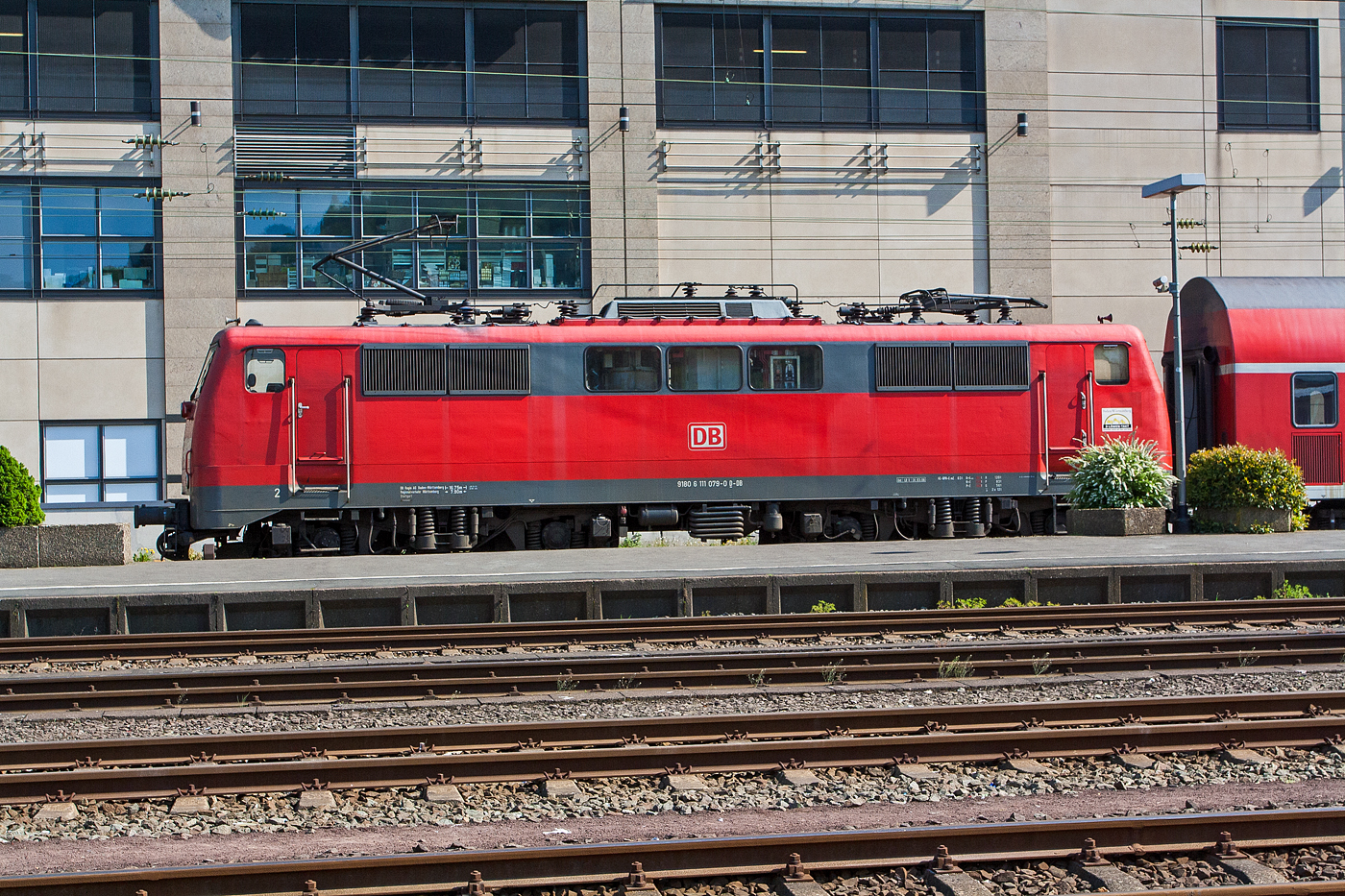 Die 111 079-0 (91 80 6111 079-0 D-DB) der DB Regio Baden-Württemberg (vermietet an die DB Regio NRW) steht am 23.04.2011 als Schublok von RE 9 (Rhein-Sieg-Express) Siegen-Köln-Aachen im Hauptbahnhof Siegen zur Abfahrt bereit. Die Aufnahme entstand aus dem SEM Siegen heraus.

Die Lok wurde 1978 von Krauss-Maffei AG in München-Allach unter der Fabriknummer 19837 gebaut. Seit 2020 ist sie im SSM (Stillstandsmanagement) in Leipzig-Engelsdorf abgestellt.

