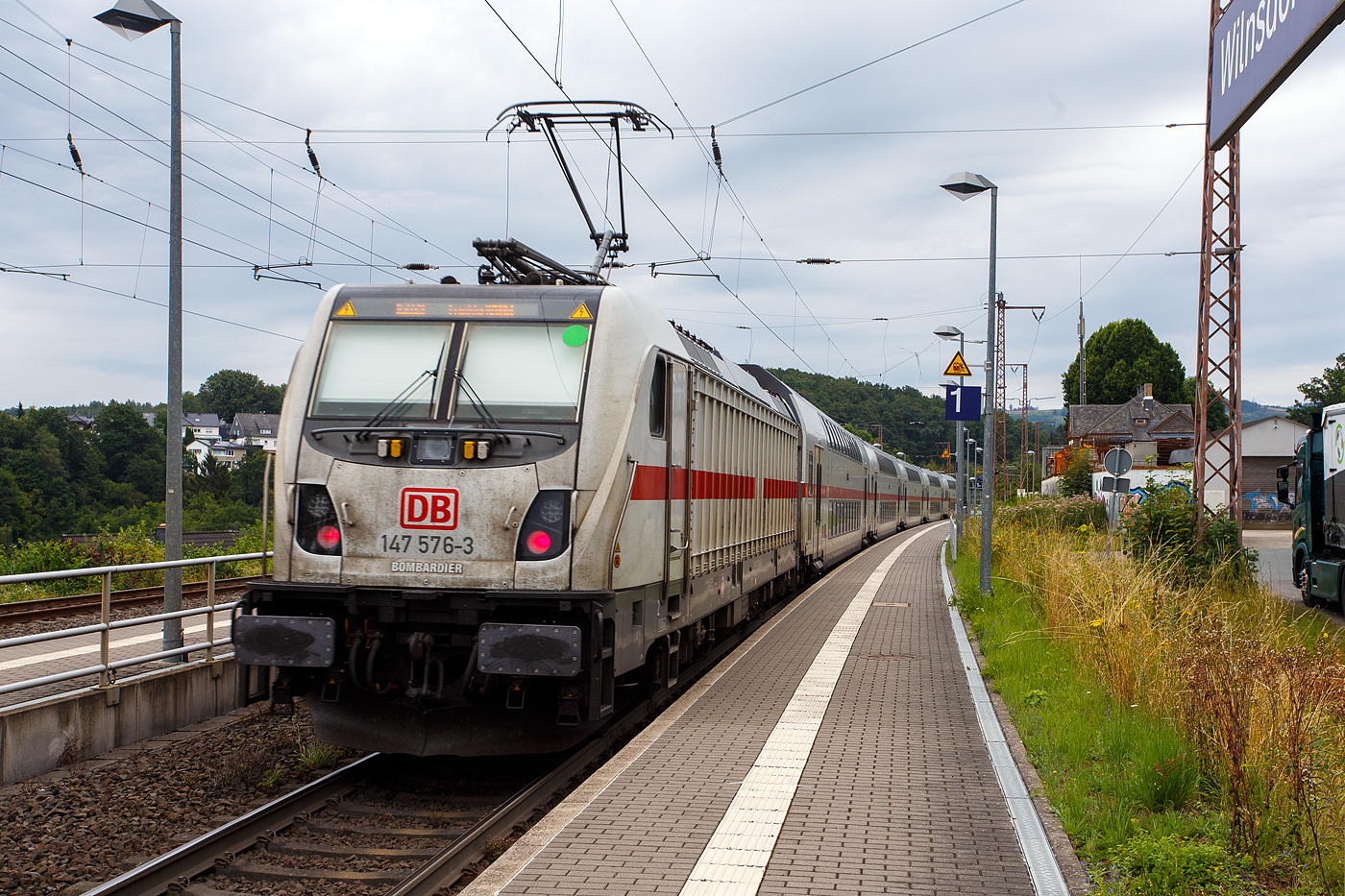 Die 147 576 (91 80 6147 576-3 D-DB – IC 4903) der DB Fernverkehr AG schiebt die IC2-Garnitur 4903, als IC 2229 / RE 34 - Umlauf RE 52229 (Dortmund Hbf – Siegen – Dillenburg Frankfurt/Main Hbf, Steuerwagen voraus am 01 August 2024 durch Wilnsdorf-Rudersdorf (Kreis Siegen) in Richtung Frankfurt/Main.

Die TRAXX P160 AC3 wurde 2020 von Bombardier in Kassel gebaut und an die DB Fernverkehr AG geliefert. Sie hat die Zulassungen für Deutschland und die Schweiz, daher hat sie auch vier Stromabnehmer. Der Bahnstrom (15.000 V 16 ⅔ Hz) ist ja derselbe, aber die Palettenbreite (Wippe) hat im SBB-Netz eine Breite von 1.450 mm und somit 500 mm schmaler als die Wippen fürs DB Netz (1.900 mm breit). Das Schleifleistenmaterial ist bei beiden aus Graphit.
