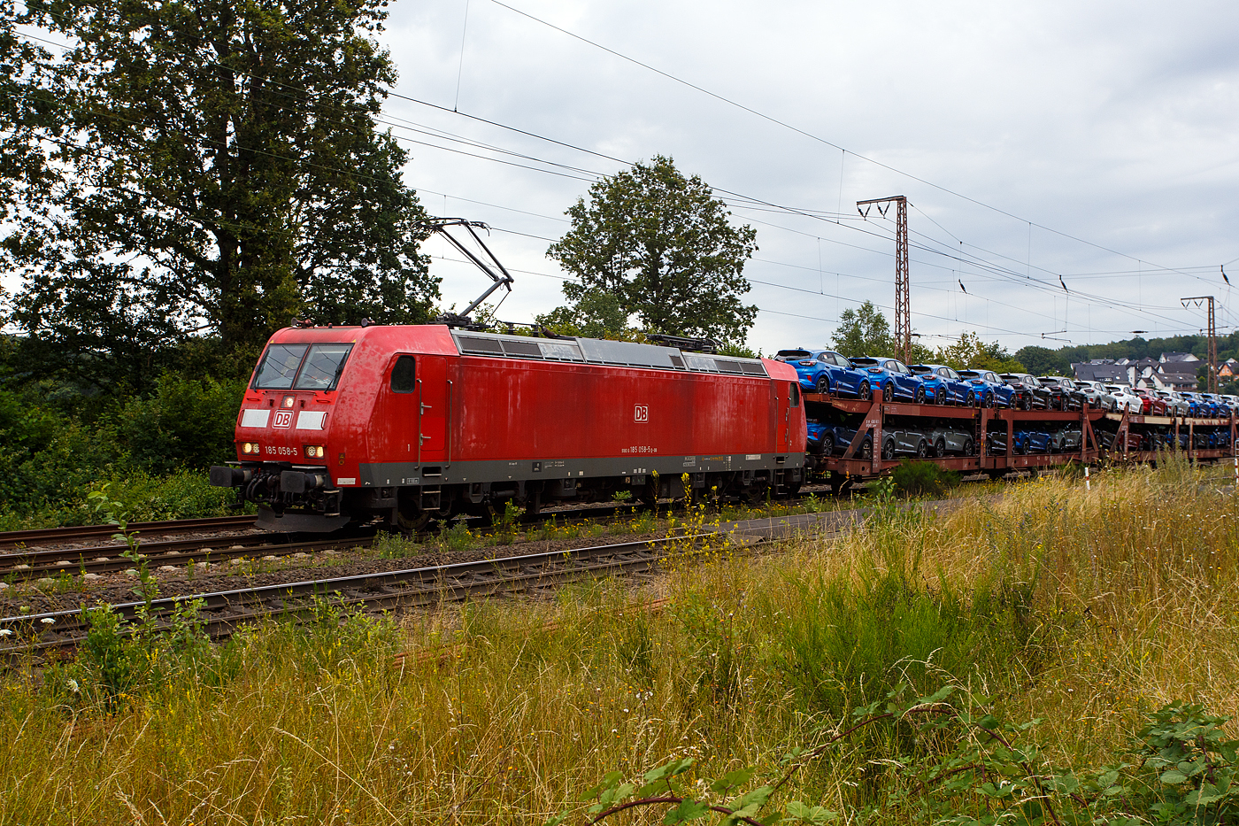 Die 185 058-5 (91 80 6185 058-5 D-DB) der DB Cargo AG fährt am 11 Juli 2024 mit einem langen beladen Autotransportzug (Wagen der Gattung Laaeks 553 der DB Cargo Logistics GmbH, ex ATG), durch Wilnsdorf-Rudersdorf (Kreis Siegen) in Richtung Siegen bzw. Kreuztal.

Nochmals einen lieben Gruß an den netten grüßenden Lokführer zurück, mich freuen immer die Grüße.

Die TRAXX F140 AC1 wurde 2002 von Bombardier in Kassel unter der Fabriknummer 33467 gebaut.
